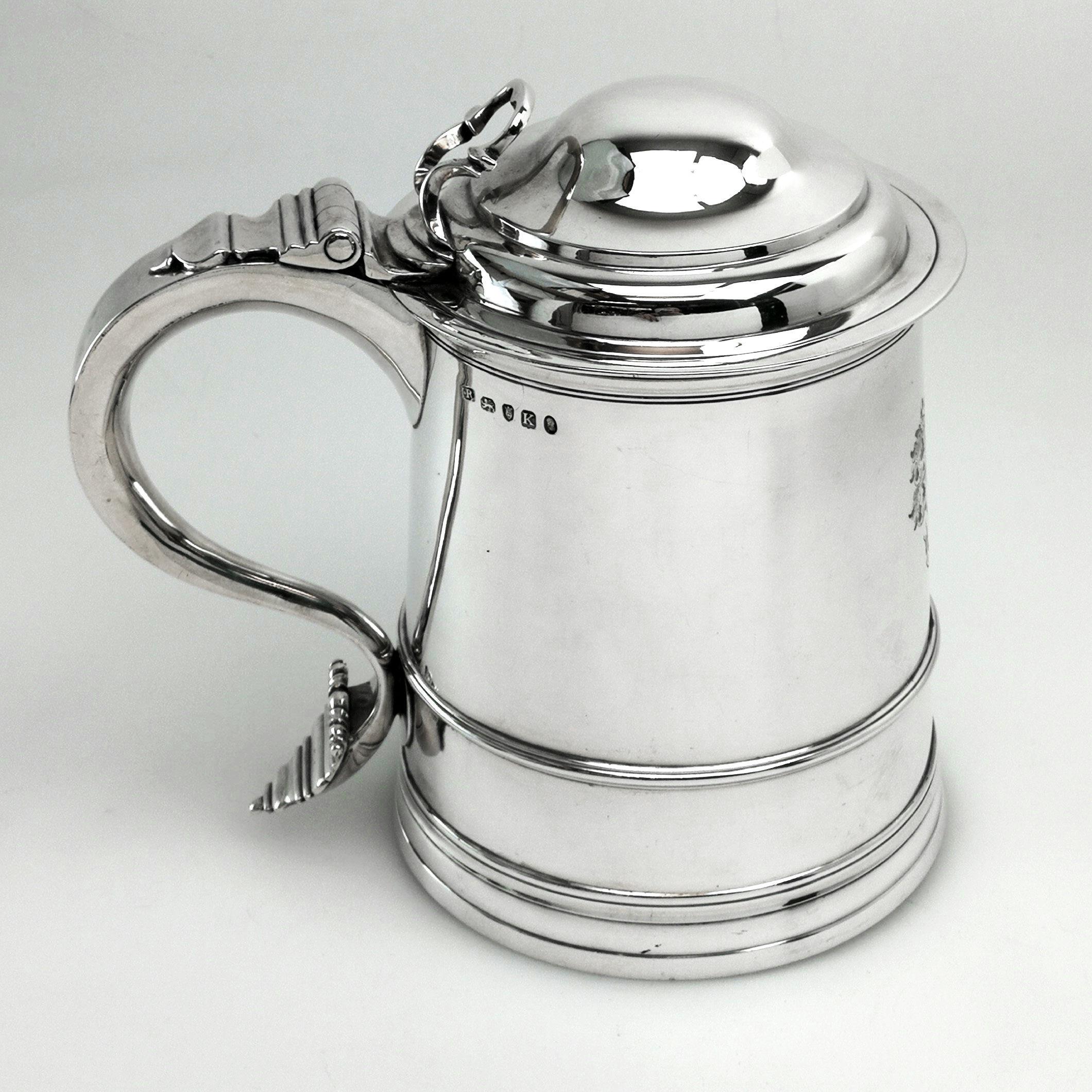 A Classic George III antique sterling silver tankard with a domed lid and a substantial scroll handle. The tankard is in a traditional straight sided form with a large crest engraved opposite the handle.
 
 Date: 1805.
 Made in London.
 Maker:
