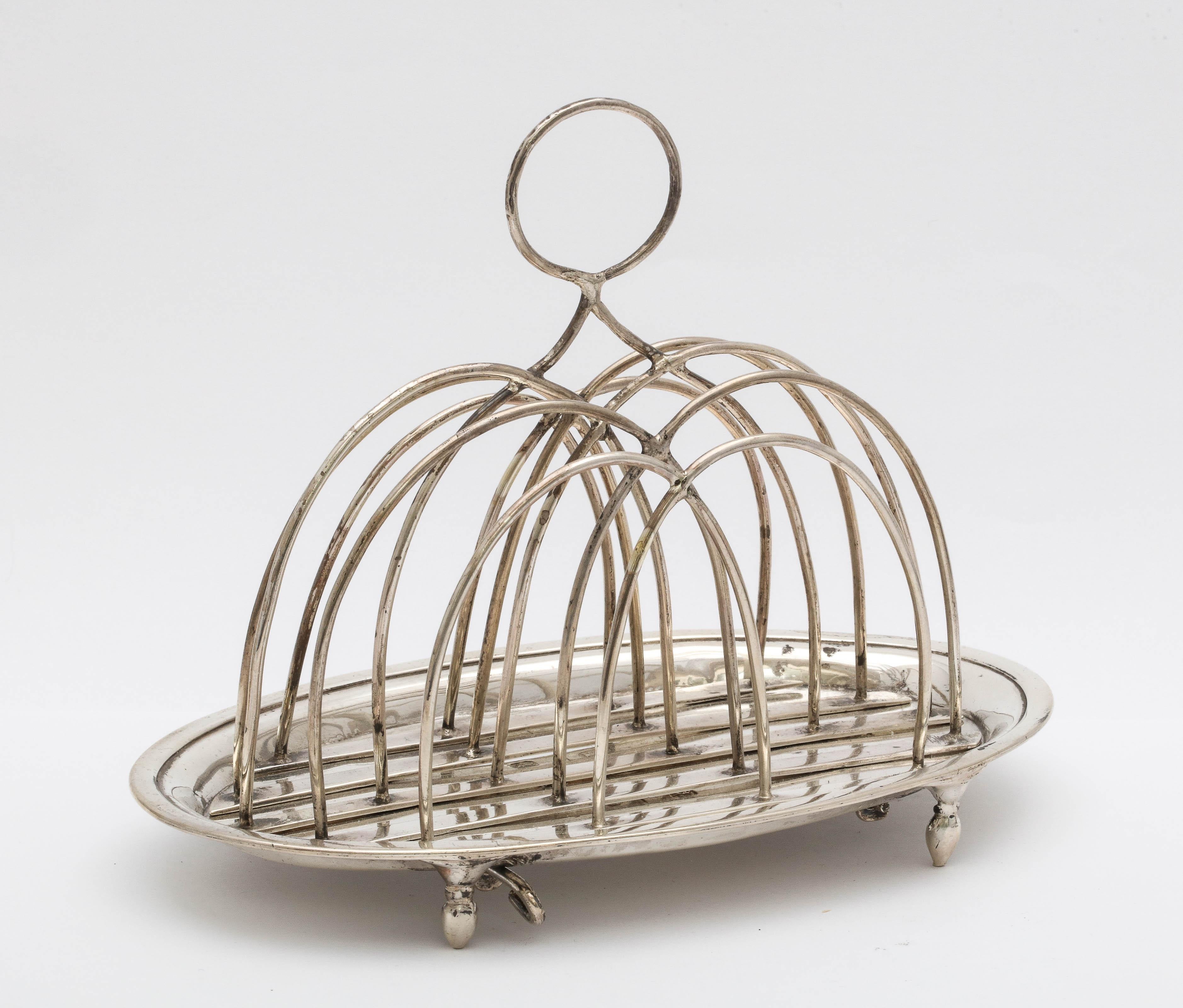Georgian (George III), sterling silver, footed toast rack, London, 1784, Barrage Davenport - maker. Measures 5 inches to top of handle x 6 inches wide x 3 3/4 inches deep. Silver wire separators are removable for cleaning (see photos of underside of