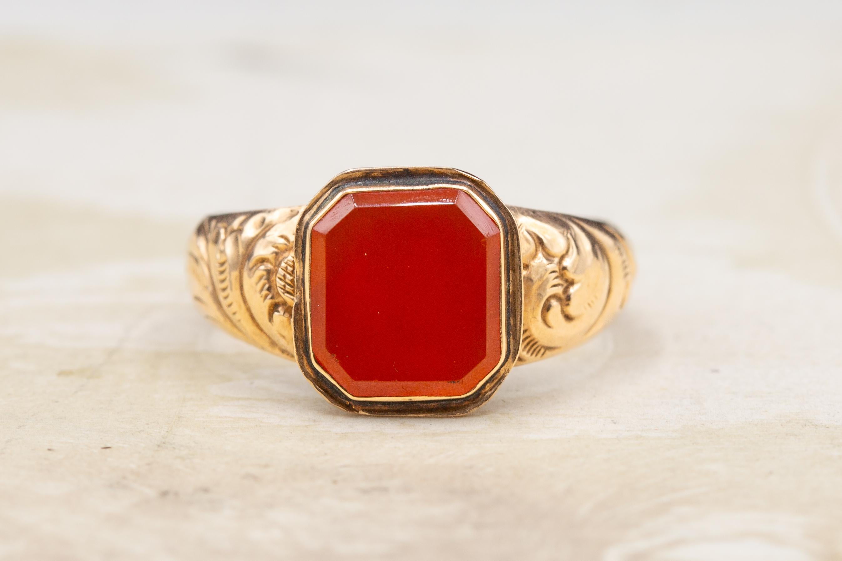 A large antique English Georgian era gentleman’s gold signet ring, circa 1830. 

In the centre there is a flat-cut and bezel-set octagonal carnelian gemstone. These stones in these types of rings would typically be engraved with a coat of arms or