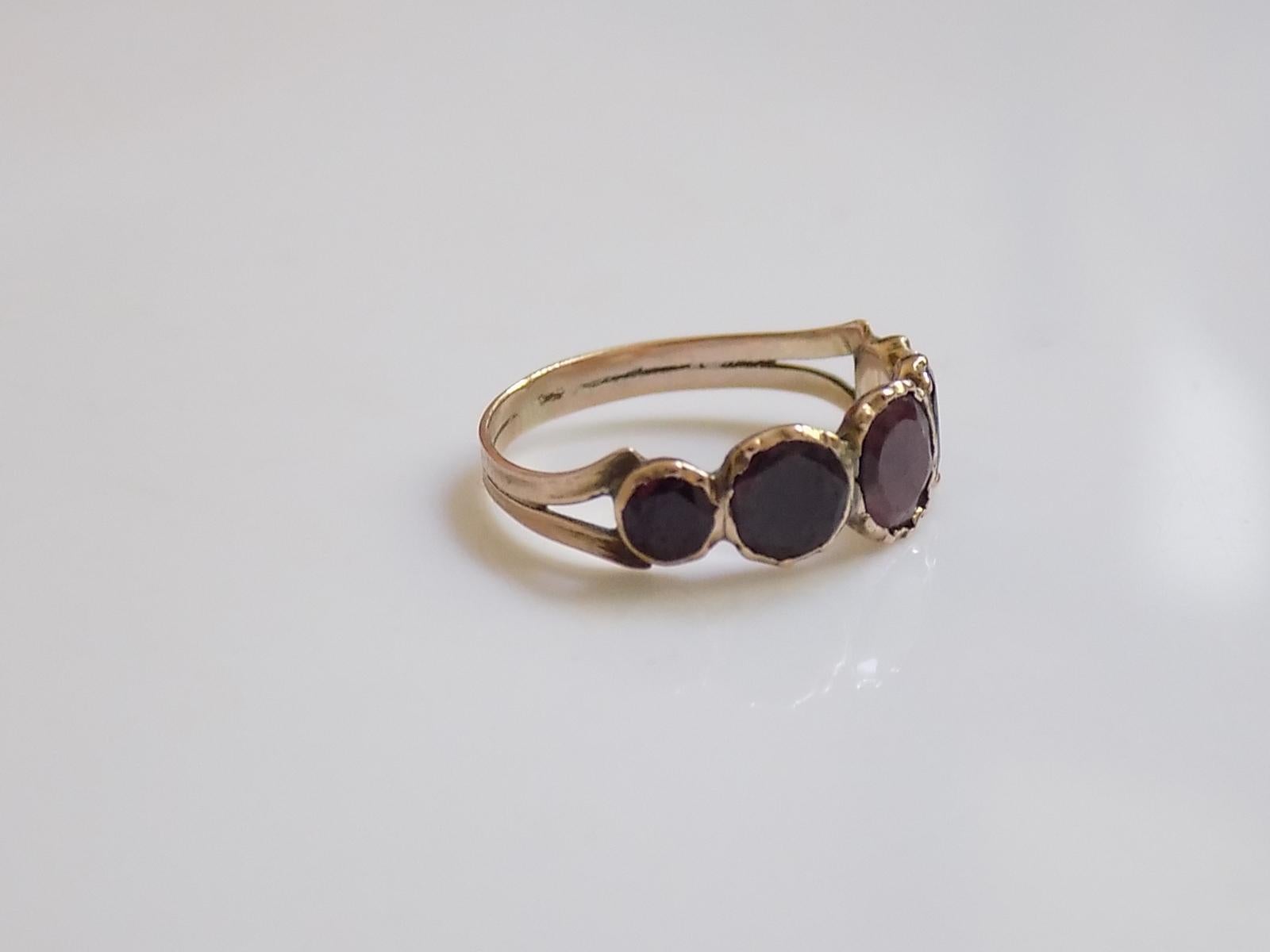 A Lovely Georgian c.1800 Rose Gold and five flat cut Garnet ring. The stones in closed back setting. English origin.
Size I UK, 4.5 US.
Height of the face 6mm.
Weight 1.2gr.
Unmarked.
The ring in very good condition for the age and ready to wear.