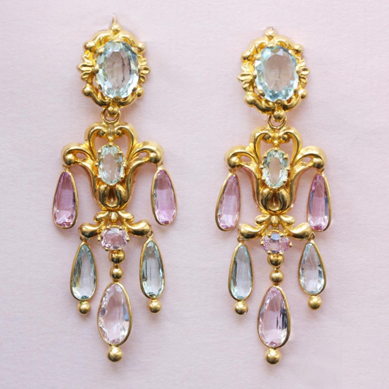 A pair of 18-carat gold girandole day and night earrings, with repoussé gold floral decorations, the tops set with oval facetted aquamarines with a floral border, below which are removable ornaments with an oval aquamarine in the middle and an oval