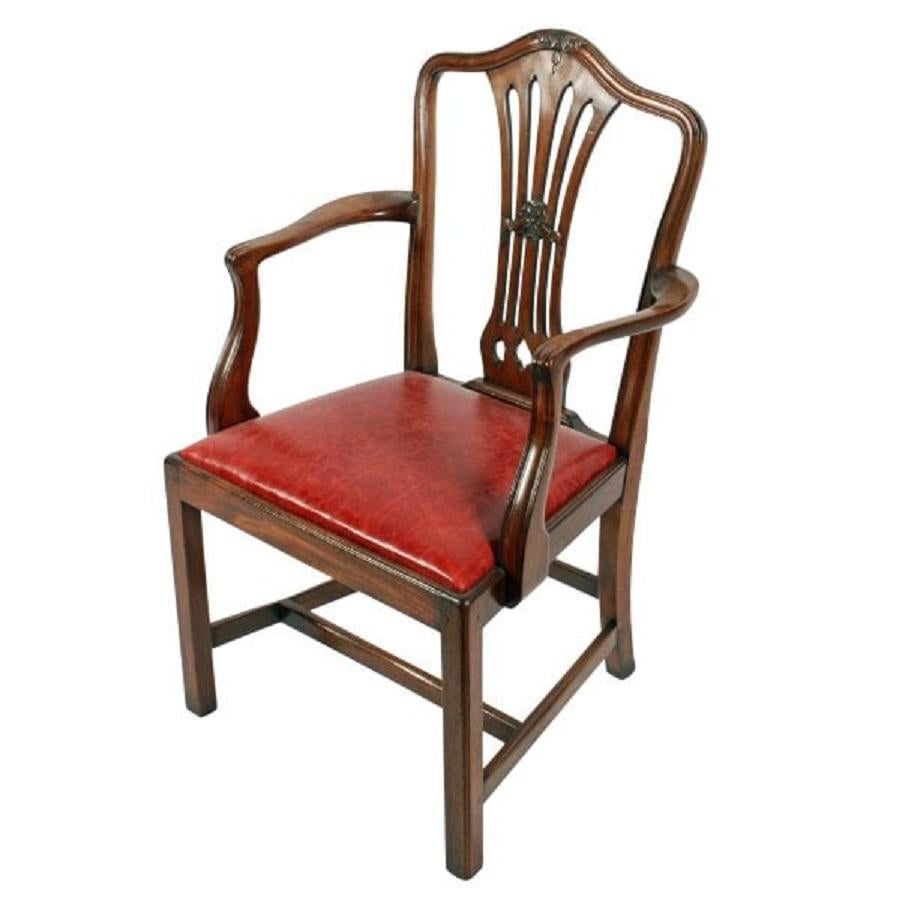 A Georgian mahogany Hepplewhite elbow or arm chair.

The chair has a serpentine shaped top rail to the back, a broad pierced centre splat carved with acanthus and ribbons and a leather upholstered seat.

The shaped arms have a reeded detail to