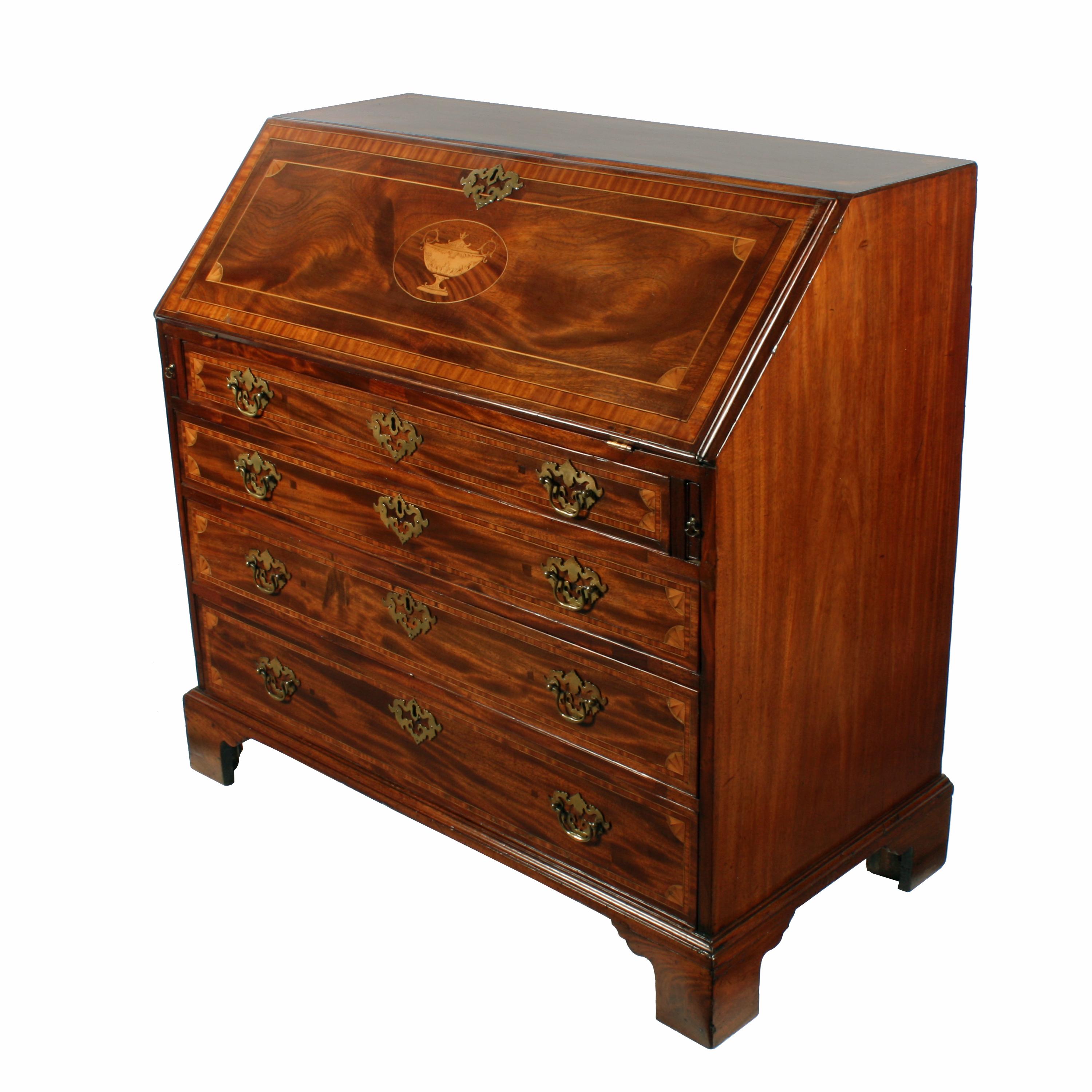 A late 18th-early 19th century Georgian mahogany bureau with later marquetry, satinwood and box wood inlays.

The bureau has four graduated oak lined drawers that have pierced brass handles which are not original.

The drawer fronts are