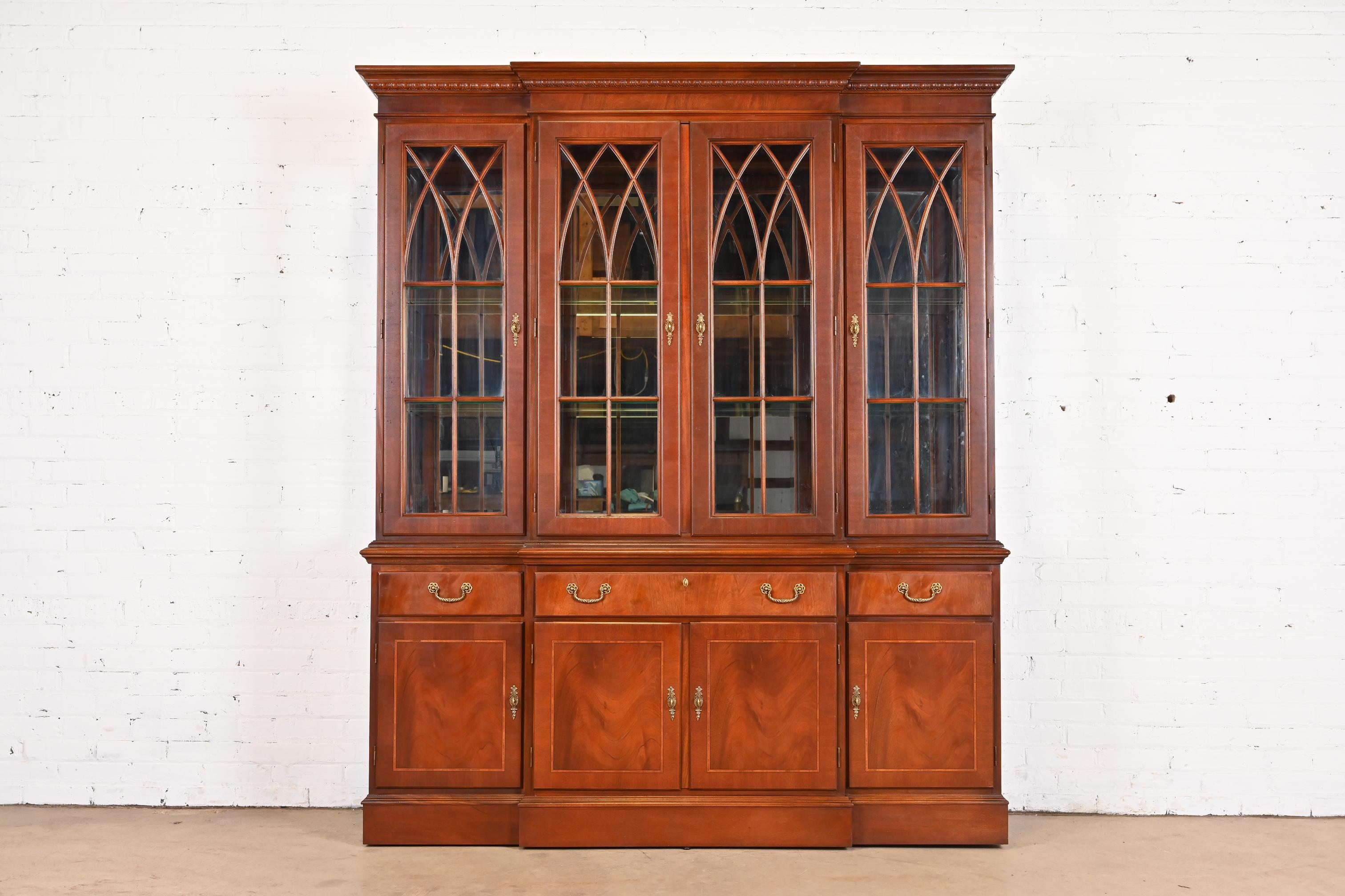 A gorgeous Georgian or Chippendale style lighted breakfront bookcase, dining cabinet, or bar cabinet

USA, Late 20th Century

Beautiful carved mahogany, with satinwood inlay, mullioned glass front doors, mirrored glass backing, and original brass