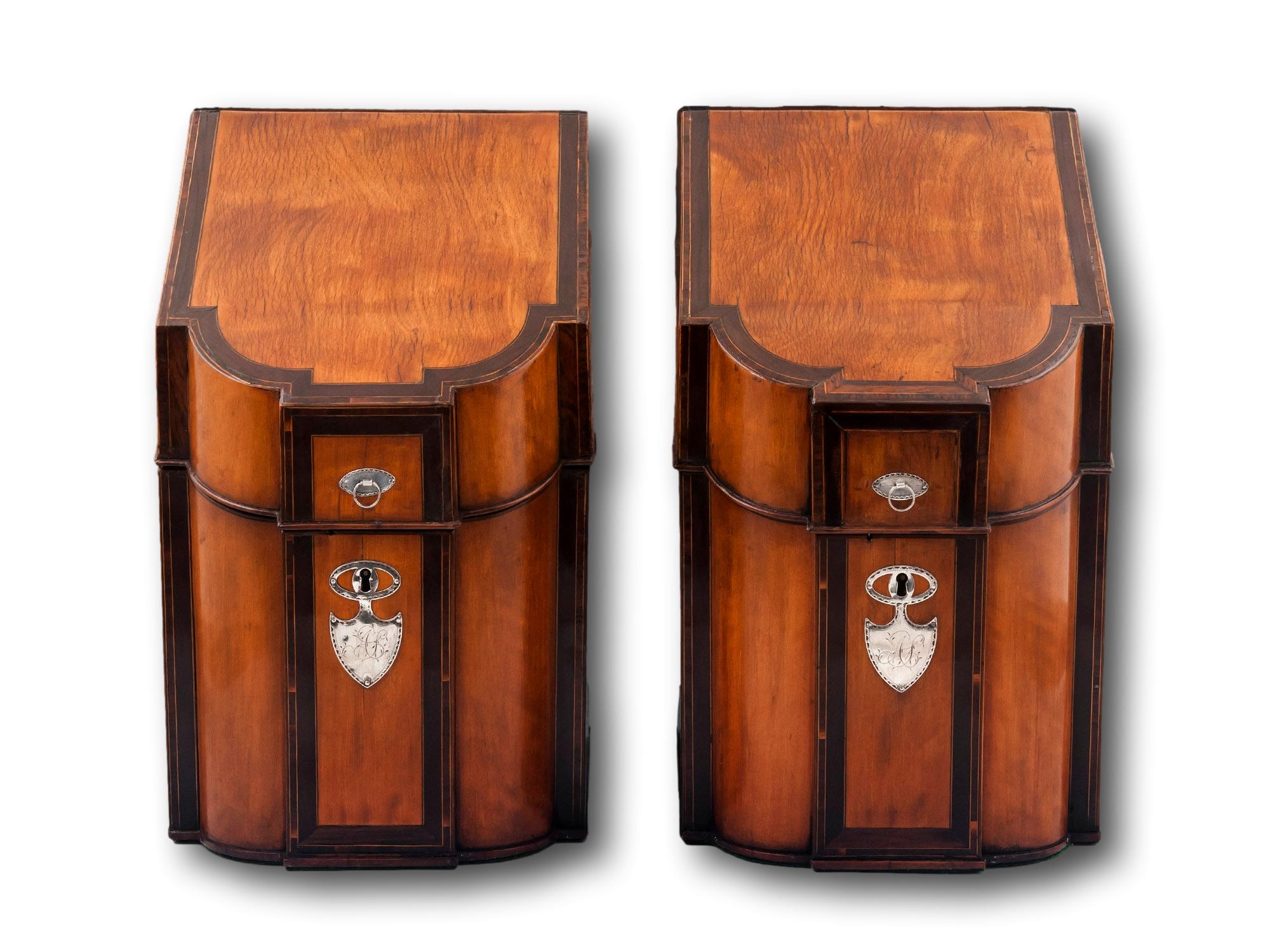 Presented with Silver Shield Escutcheons

From our Knife Boxes collection, we are delighted to offer this pair of Georgian Satinwood Knife Boxes. The Knife Boxes with sloping tops and breakfront D-shaped sections veneered in Satinwood with Laburnum