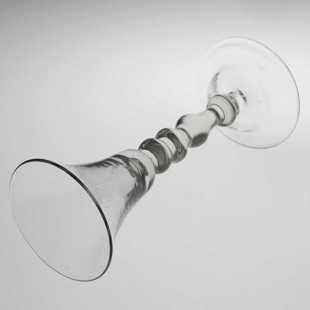 Heading : Light baluster stem Georgian wine glass
Period : George II - c1735
Origin : England
Colour : Clear
Bowl : Bell shaped
Stem : Ball knop, two inverted baluster knops above a plain stem section and ball knop cushion
Foot : Domed
Pontil :