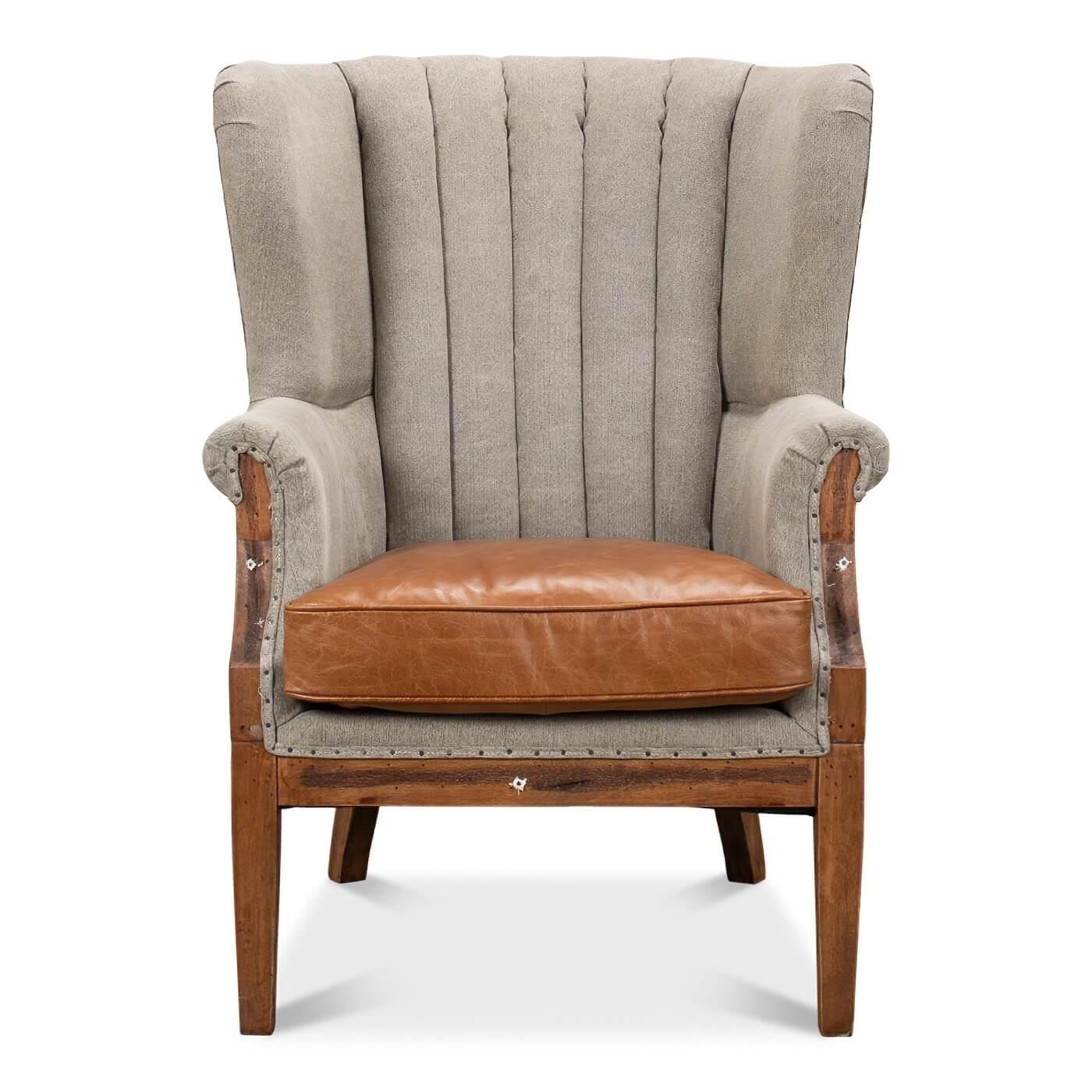 A channel-back linen and leather wingchair with a unique deconstructed back and sides design. This chair is a beautiful combination of warm-toned colors and materials. Its back and interior wings are crafted in luxurious linen and its cushioned seat