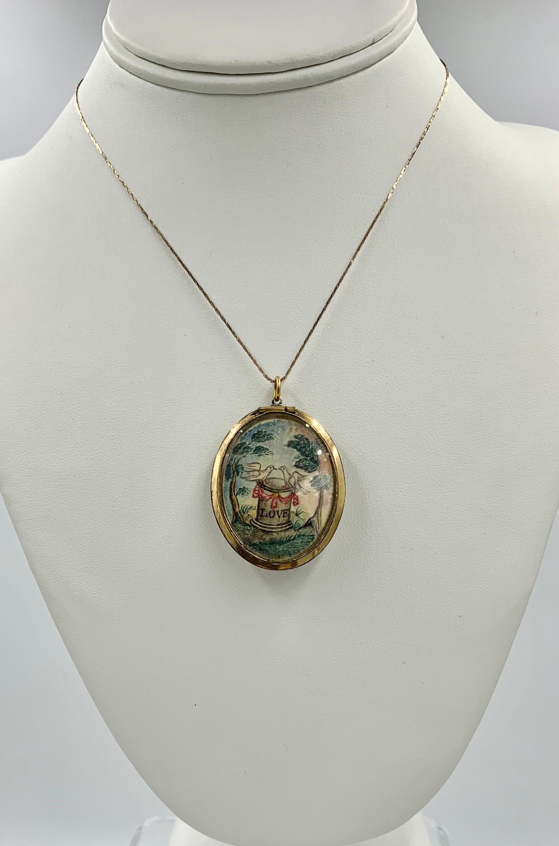 A very early and rare Museum Quality Georgian Love Token Mourning Jewelry Locket Pendant.  On one side of the locket is an exquisite miniature painting of two dove birds on a pedestal with the word LOVE below a red garland ribbon.  The pedestal or