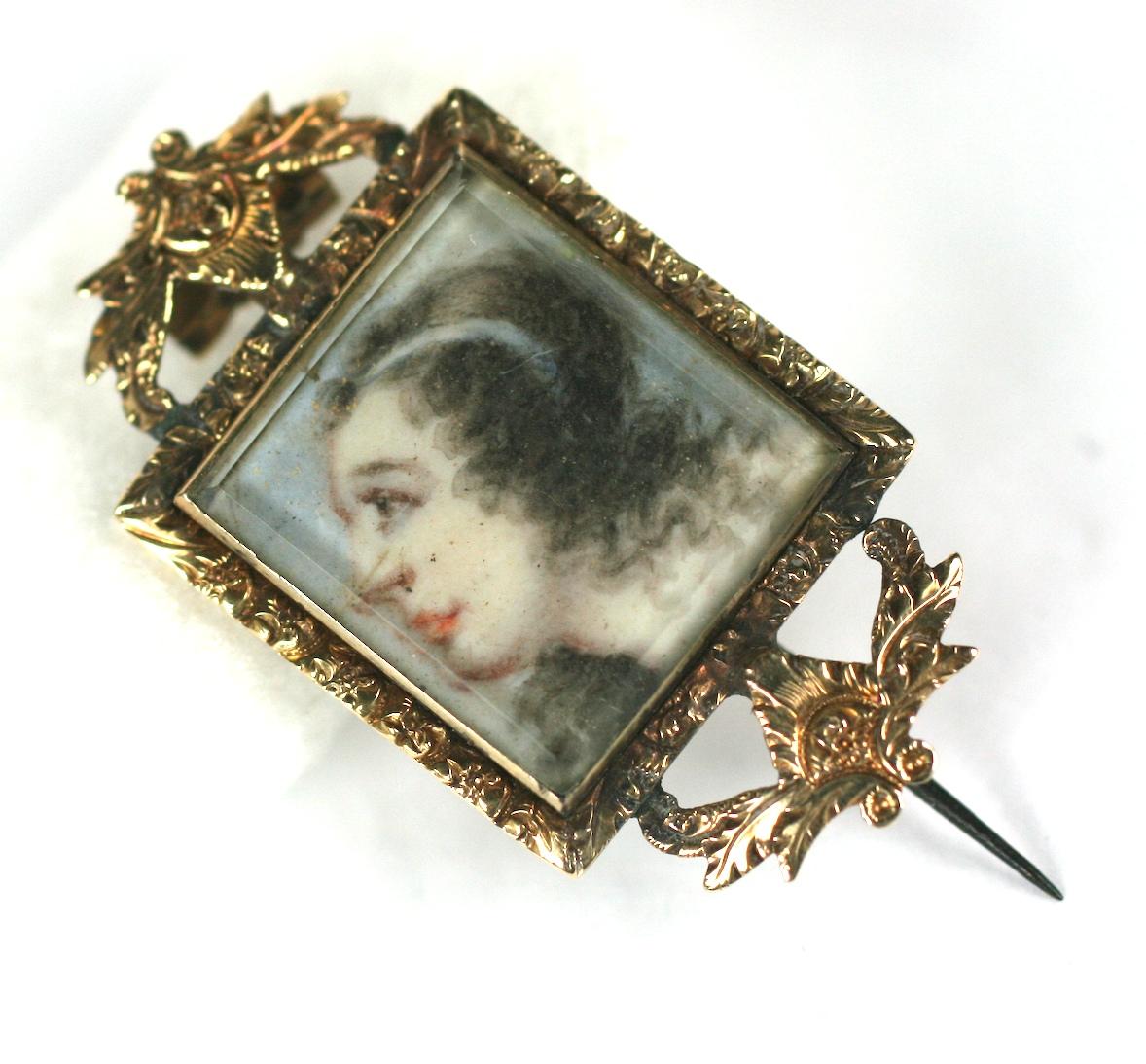 Rare Georgian Lover's Eye Brooch from the late 1700's. Painted miniature portrait of a young woman, looking upwards with white ribbon holding her hair, with a lover's eye painted on the obverse, both caught under glass panes. 
The unknown young