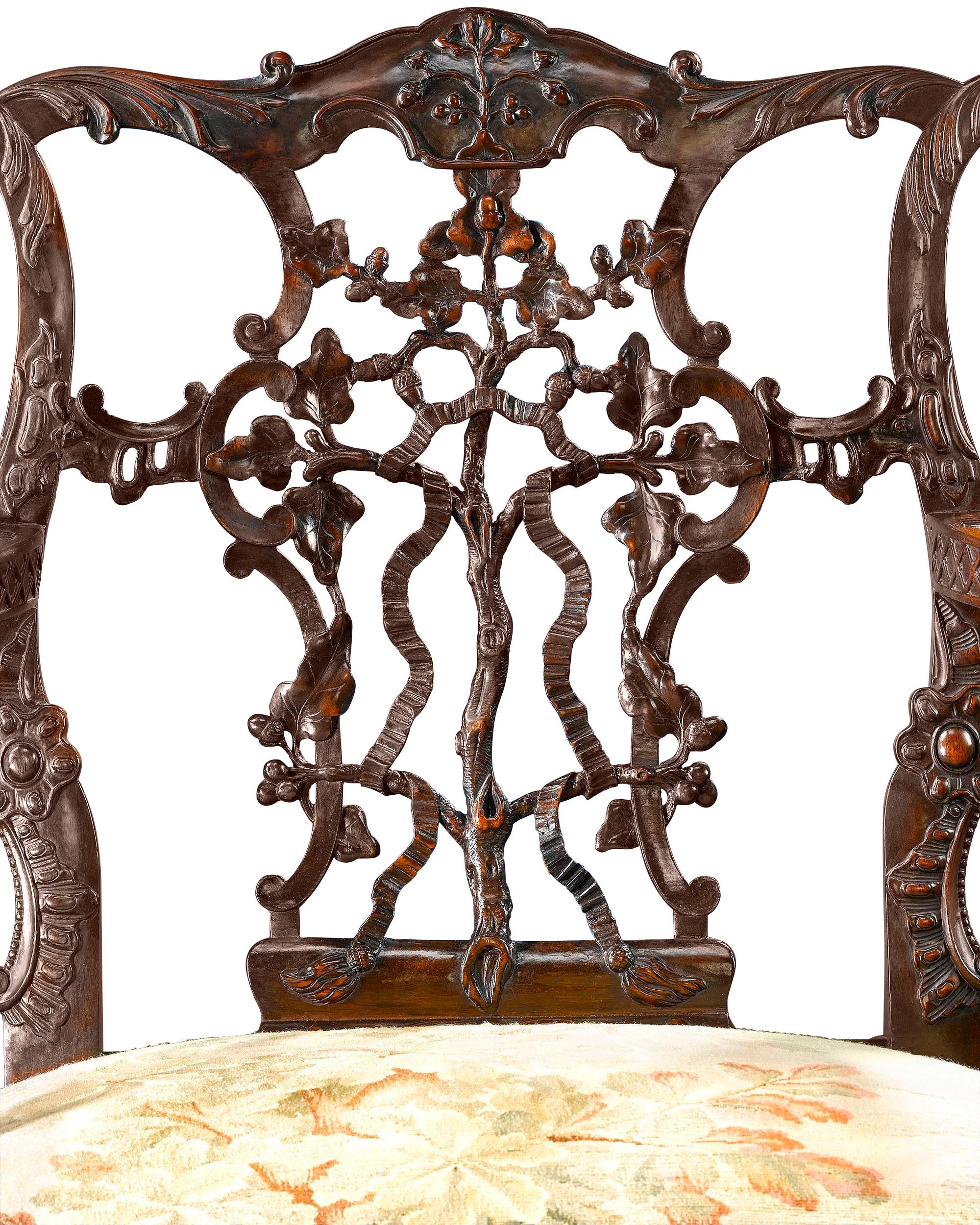 A magnificent 19th-century mahogany arm chair crafted in the George II taste. From the pierced, intertwined ribbon back and duck-form armrests to the hairy ball-and-claw feet, the quality of carving is deep and richly detailed. The seat is