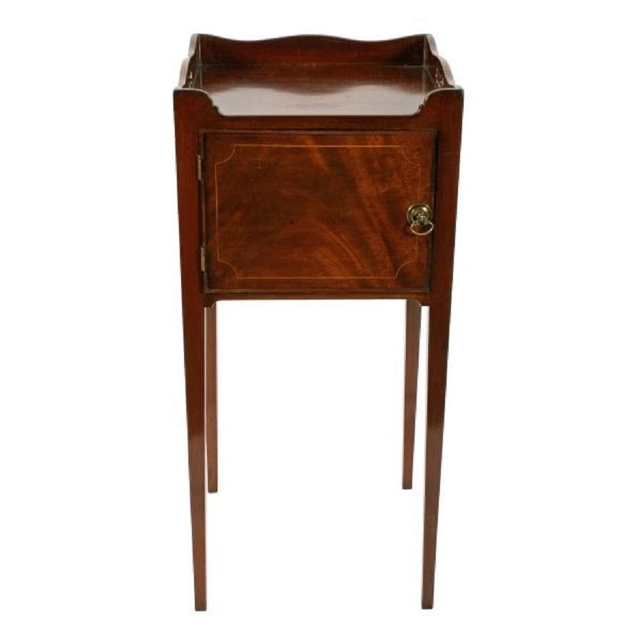 A late 18th to early 19th century Georgian mahogany bedside cabinet.

The cabinet has a left hand opening door and a tray shaped top with cut out handles.

The door has a cock beaded edge, box wood line inlay decoration and a battle-axe shaped
