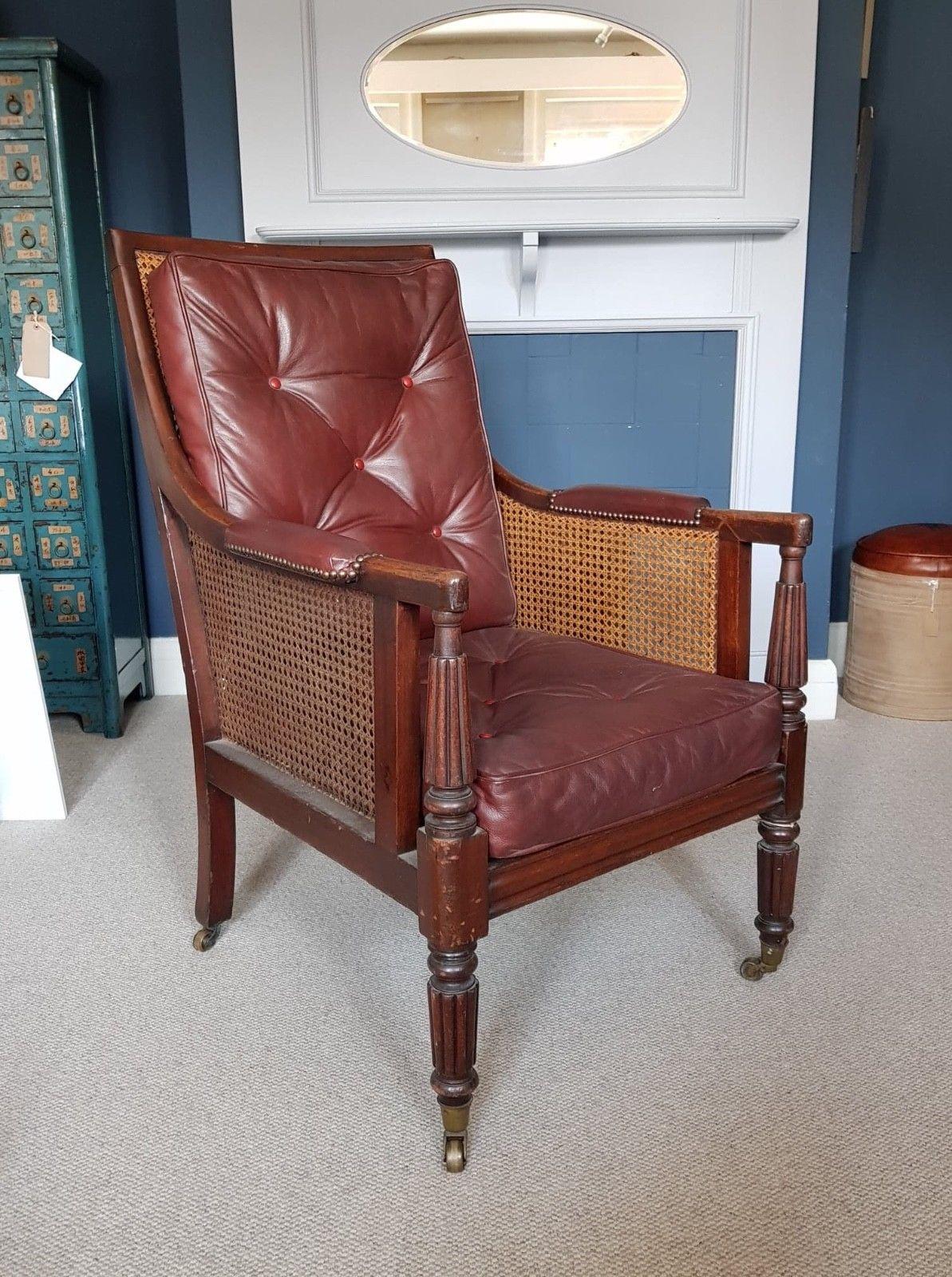 A handsome George-IV mahogany bergère armchair. Having a caned rectangular back, sides and seat. Fitted with dark burgundy buttoned leather cushions and padded armrests with attractive stud work. Tapered and reeded arm supports and front legs