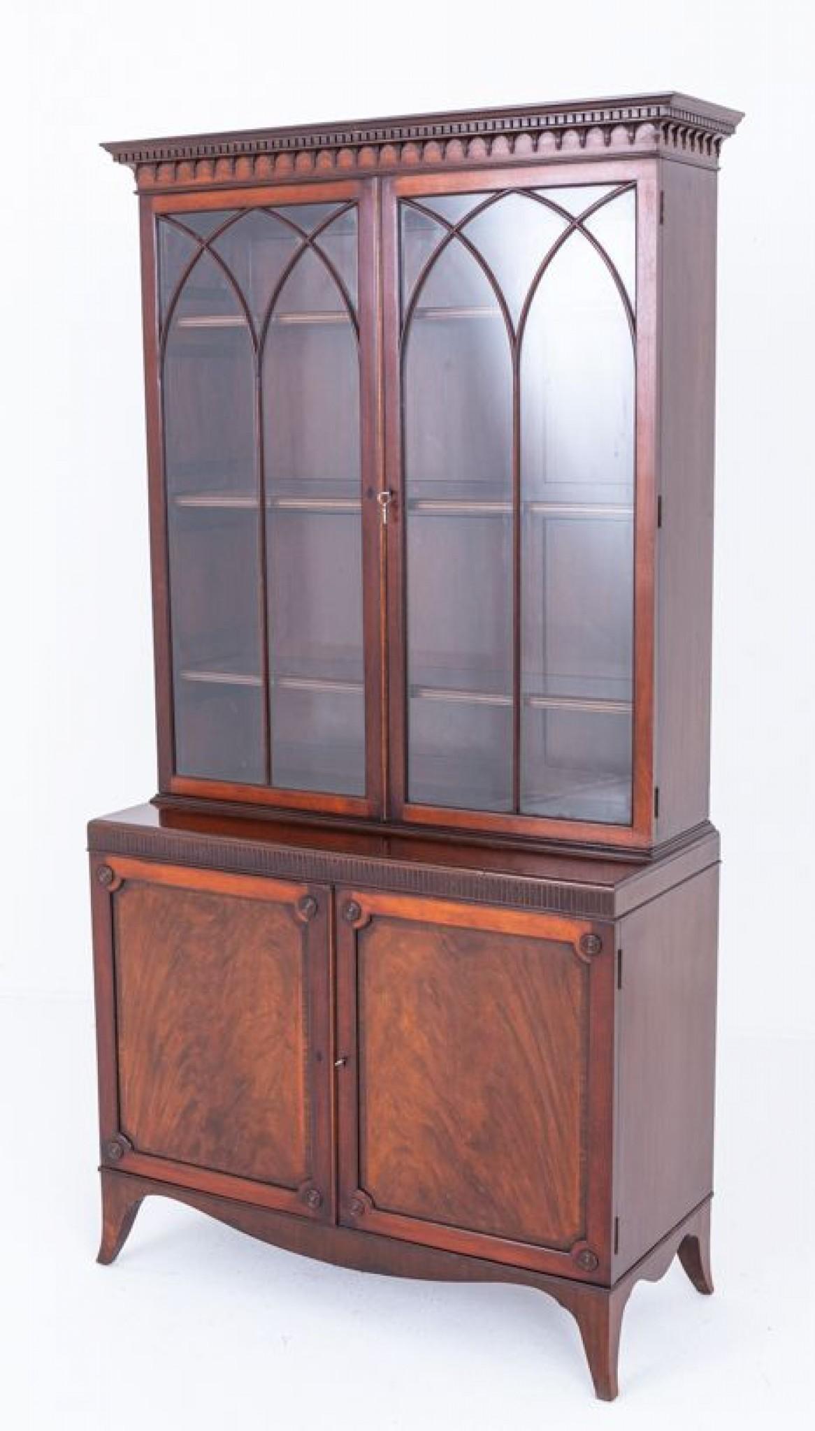 Questa libreria poggia su piedi distanziati con un grembiule sagomato.
Circa 1920
La sezione inferiore presenta porte pannellate con meravigliosi legni di mogano a fiamma, modanature astragali e dettagli torniti.
La parte superiore presenta 2 porte