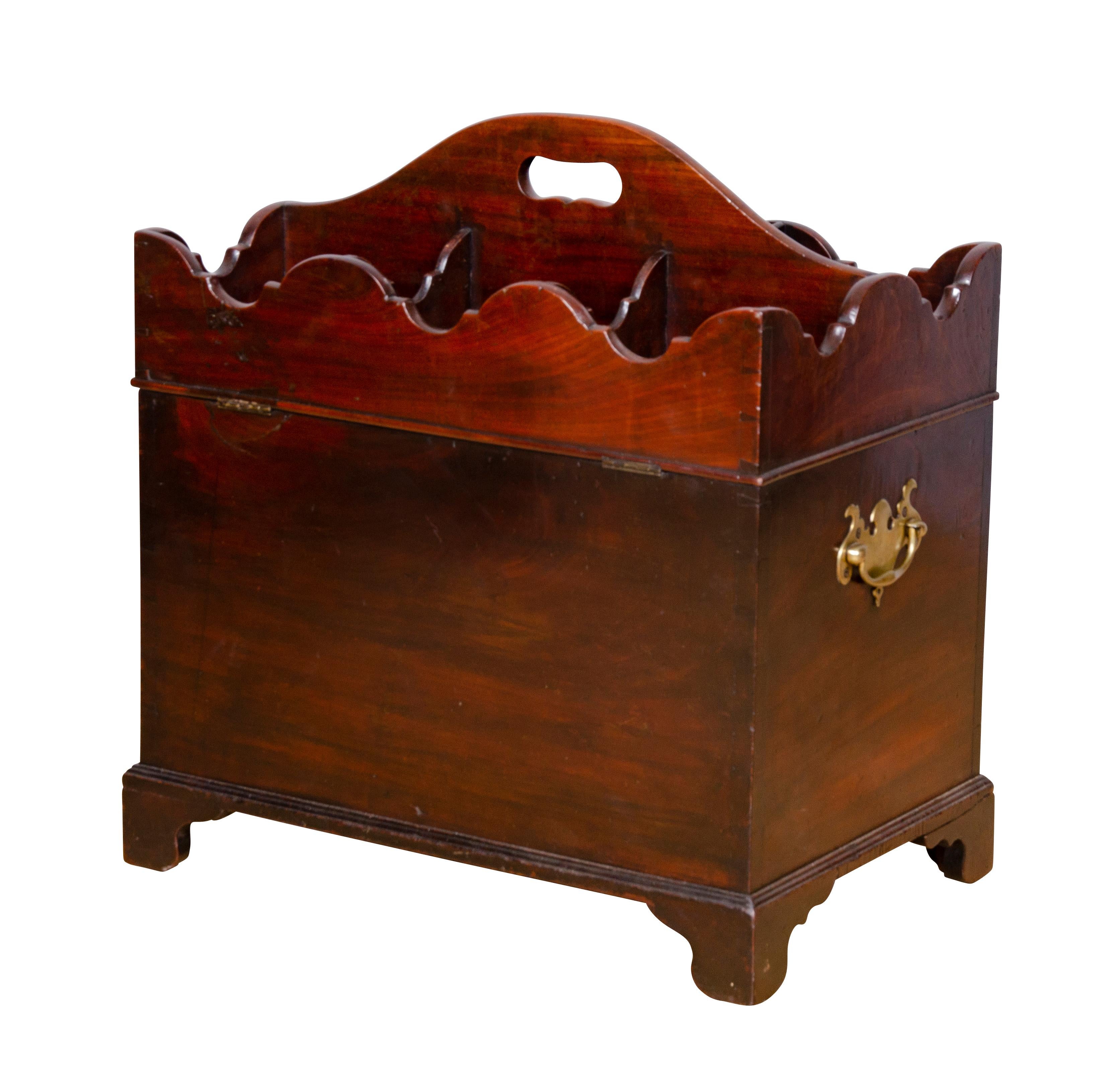 With six compartmented hinged top with arched cut out handle opening to a six compartment interior raised on bracket feet. Brass handles on sides.