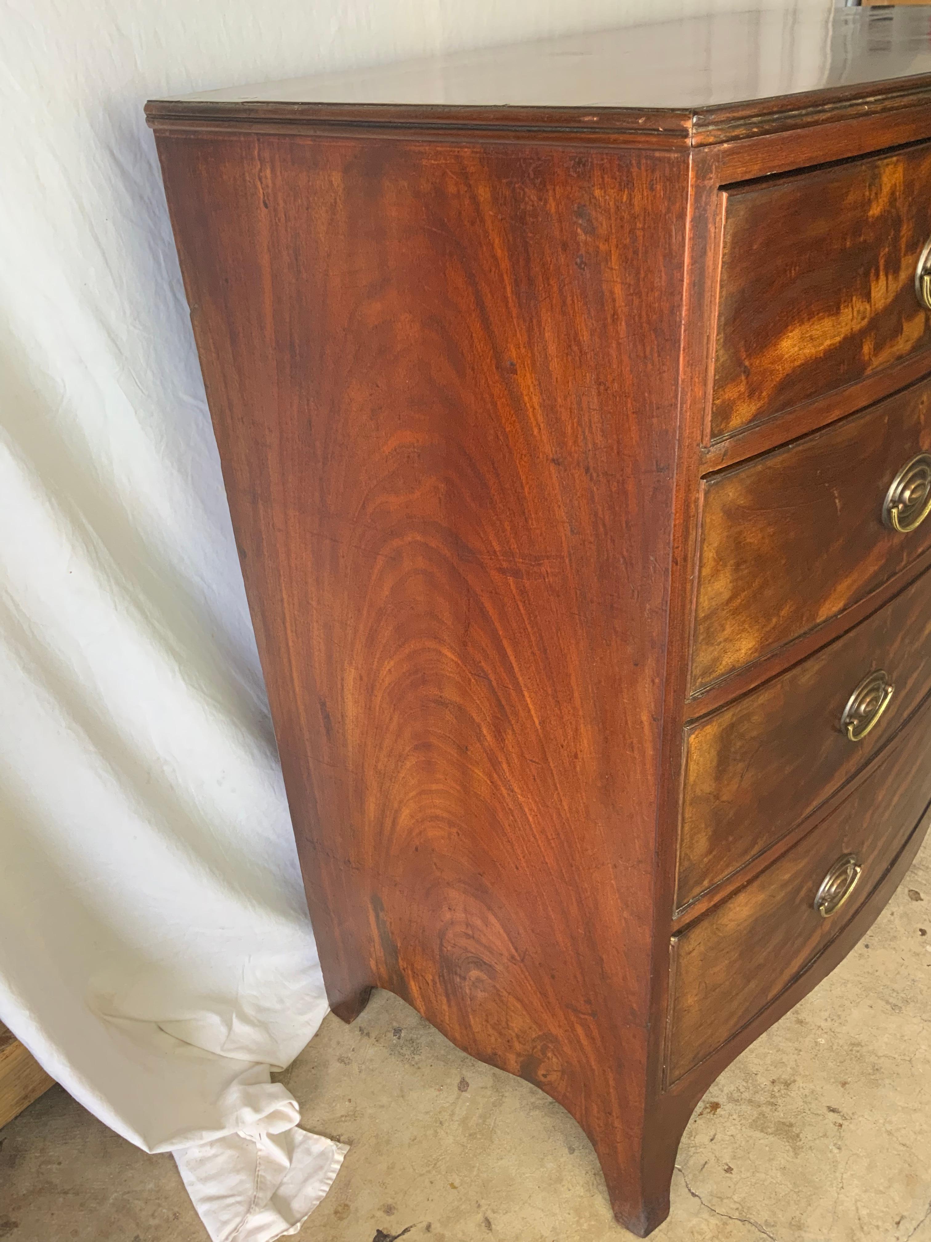 A very nice tall two over three Georgian Mahogany Bow Front Bureau sitting on tall French feet constructed out of highly figured Mahogany. This piece still retains its original surface showing a great color and a nicely aged patina. Secondary wood