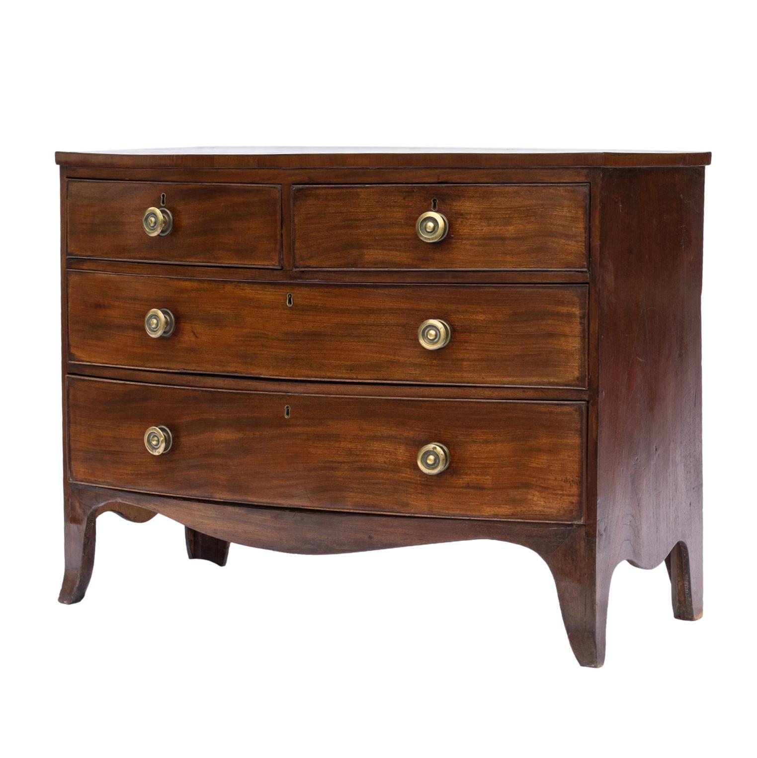 George III Mahogany Bowfront chest-of-drawers, with two short drawers above two long, with cockbeading to the drawers, on a shaped apron with saber legs, the top with satinwood and ebony stringing, with brass knob pulls, English, ca. 1820.