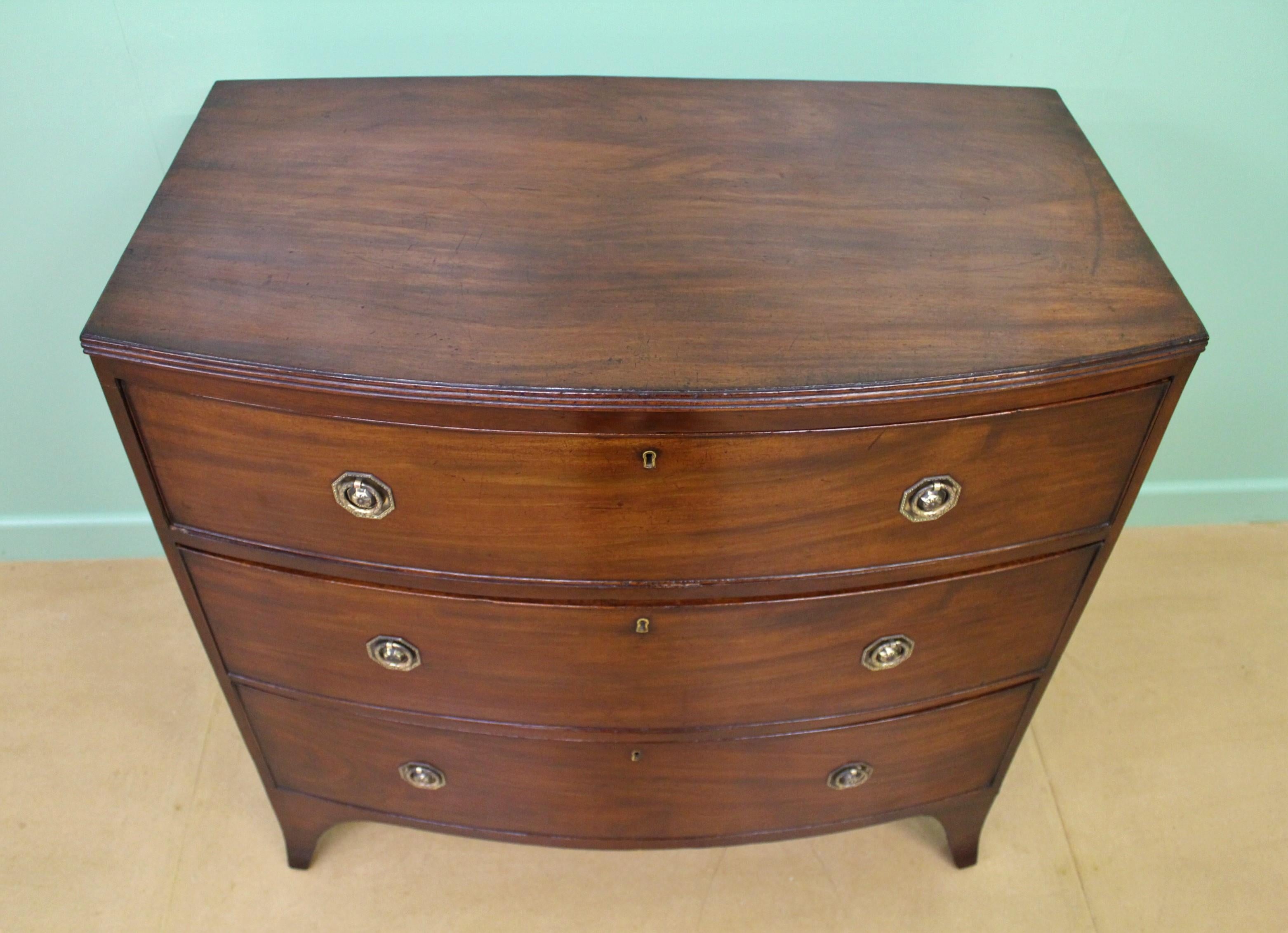 A charming Georgian mahogany bow fronted chest of drawers from the George III period. Well constructed in solid mahogany with attractive mahogany veneers. Of gentle bow fronted form and of compact proportions. With an arrangement of 3 drawers, each