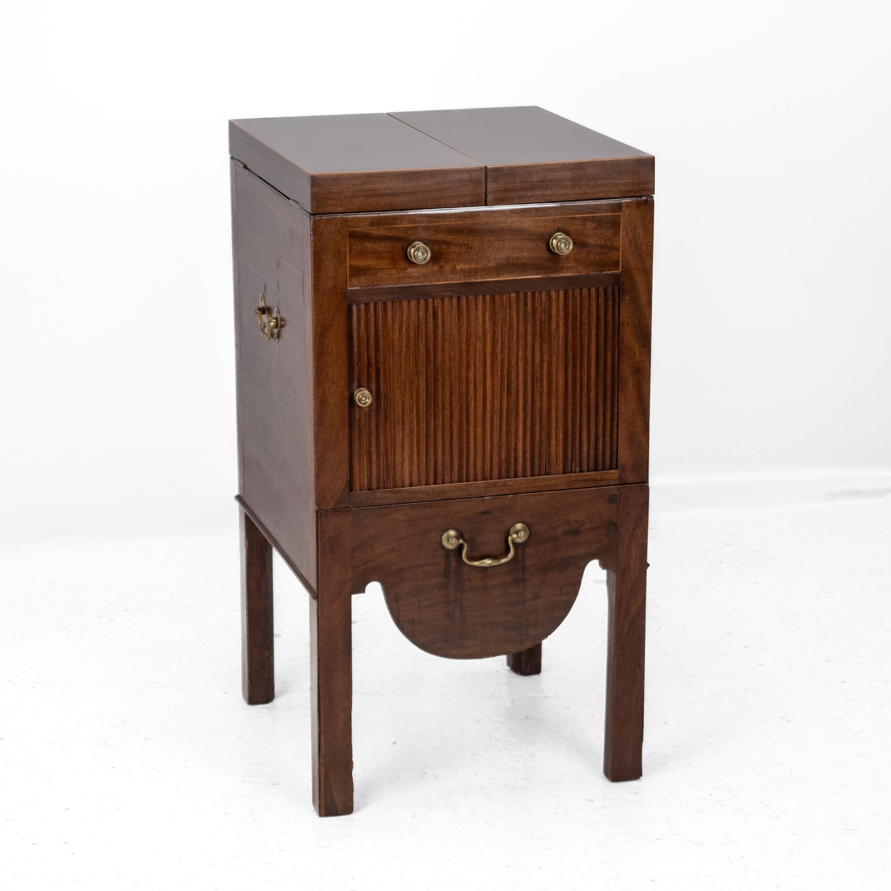 A George III Mahogany and Boxwood Inlaid Washstand, Late 18th Century

A fine George III period mahogany washstand, inlaid with boxwood stringing and displaying a warm, well-developed patina. The folding top opens to reveal an inset, retractable