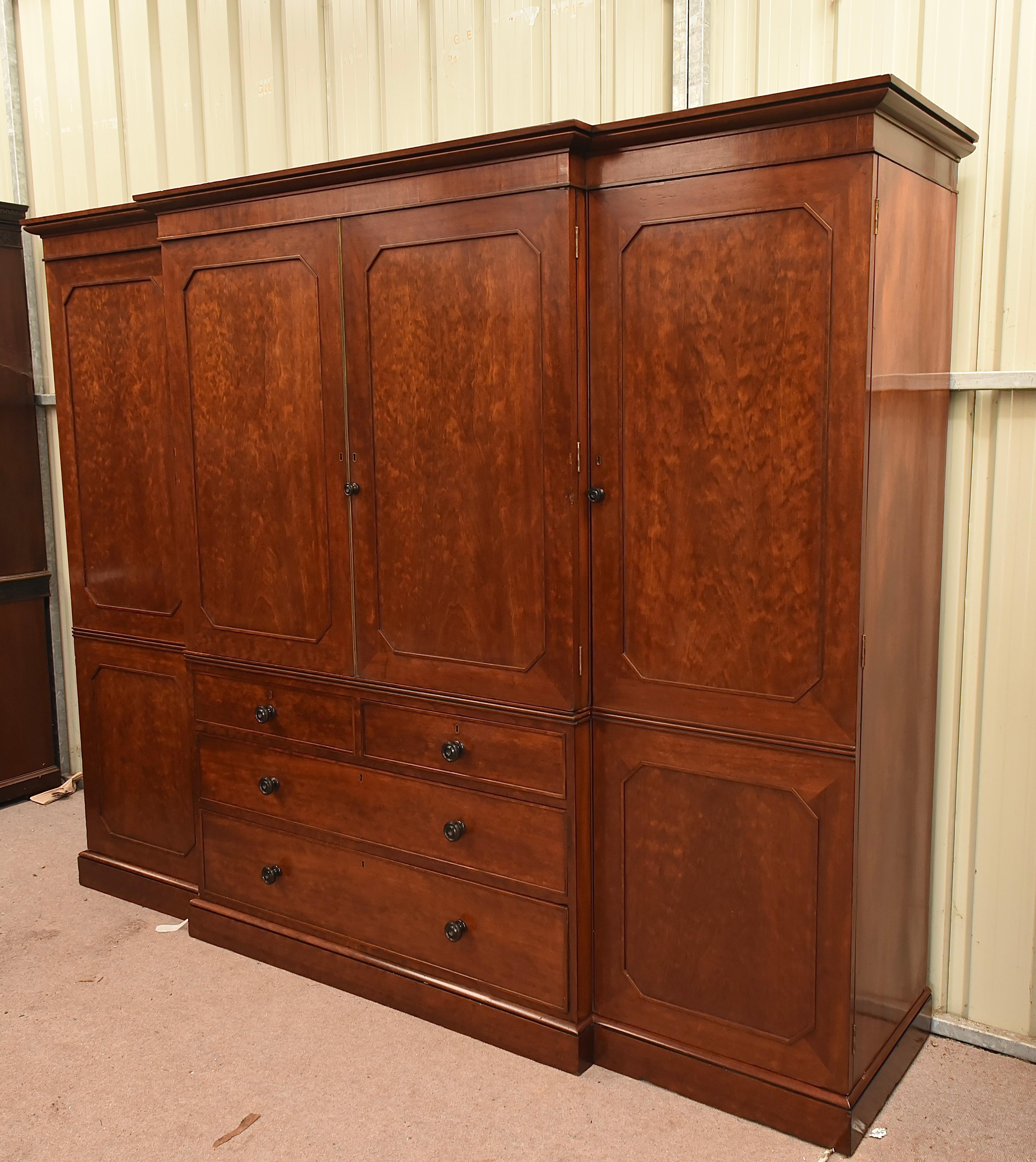 Fantastic large plum pudding mahogany breakfront compactum wardrobe attributed to Gillow 
The wardrobe is fine quality with with good figuring and a great colour .
It has a fully fitted centre with slide out linen trays with two small over two large