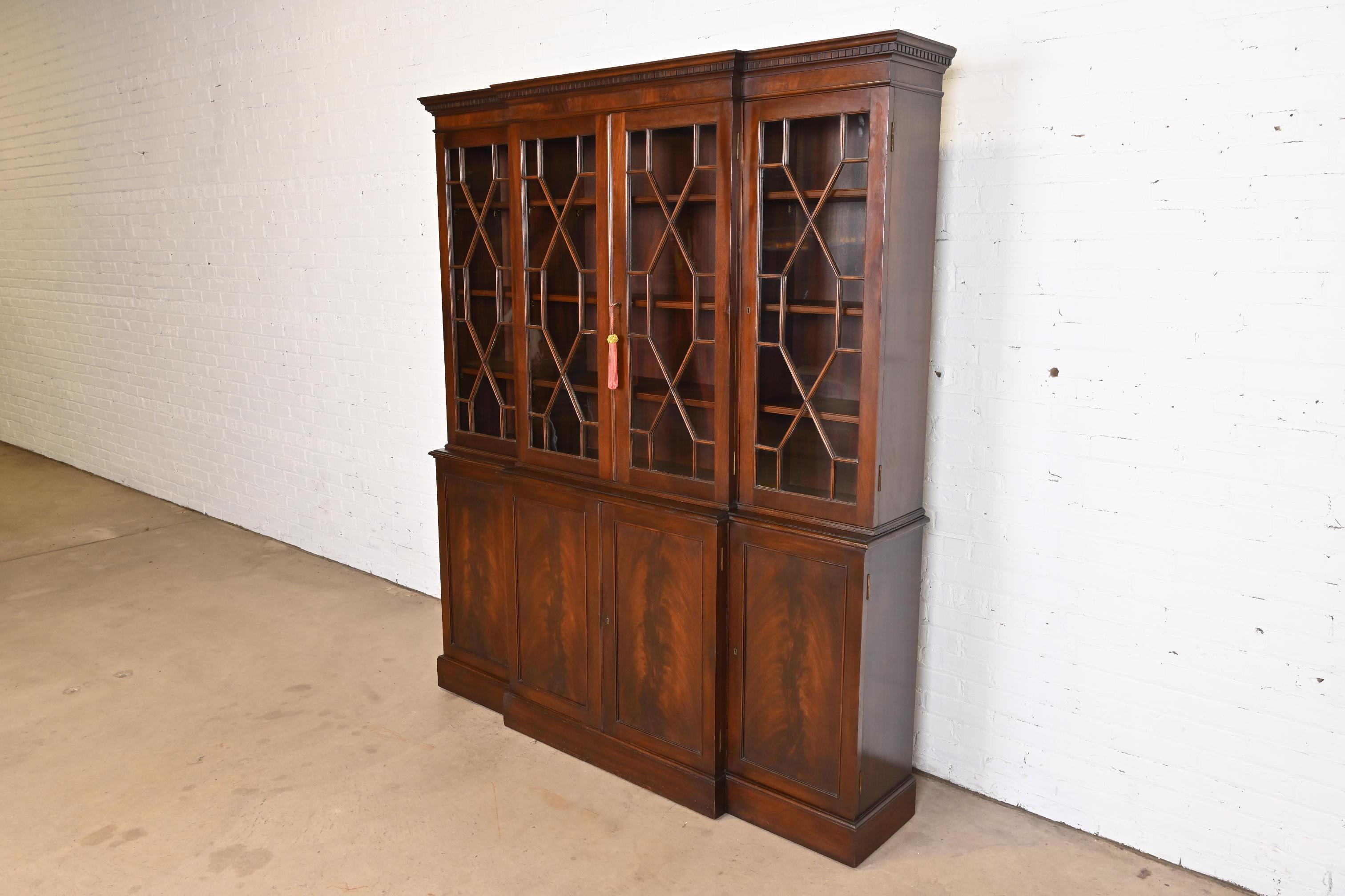 A gorgeous Georgian style breakfront bookcase cabinet

In the manner of Baker Furniture

USA, Mid-20th Century

Book-matched flame mahogany, with mullioned glass front doors. Upper and lower cabinets lock, and key is included.

Measures: