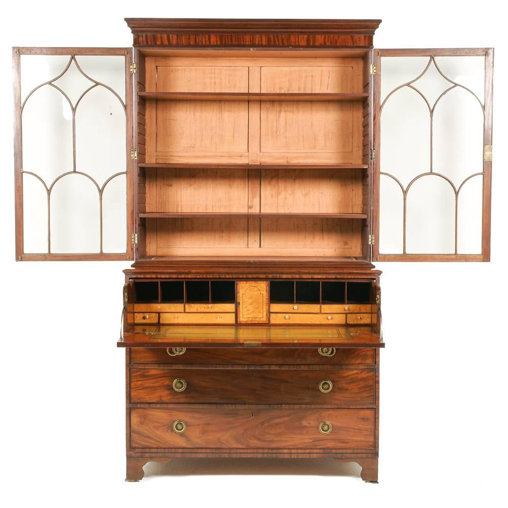A fine, English George III bureau-bookcase. The top with adjustable shelves and Gothic-influenced glazing pattern, the bottom having a finely-fitted secretary drawer over three drawers.

Beautiful colour and figuring. Older replacement pulls in