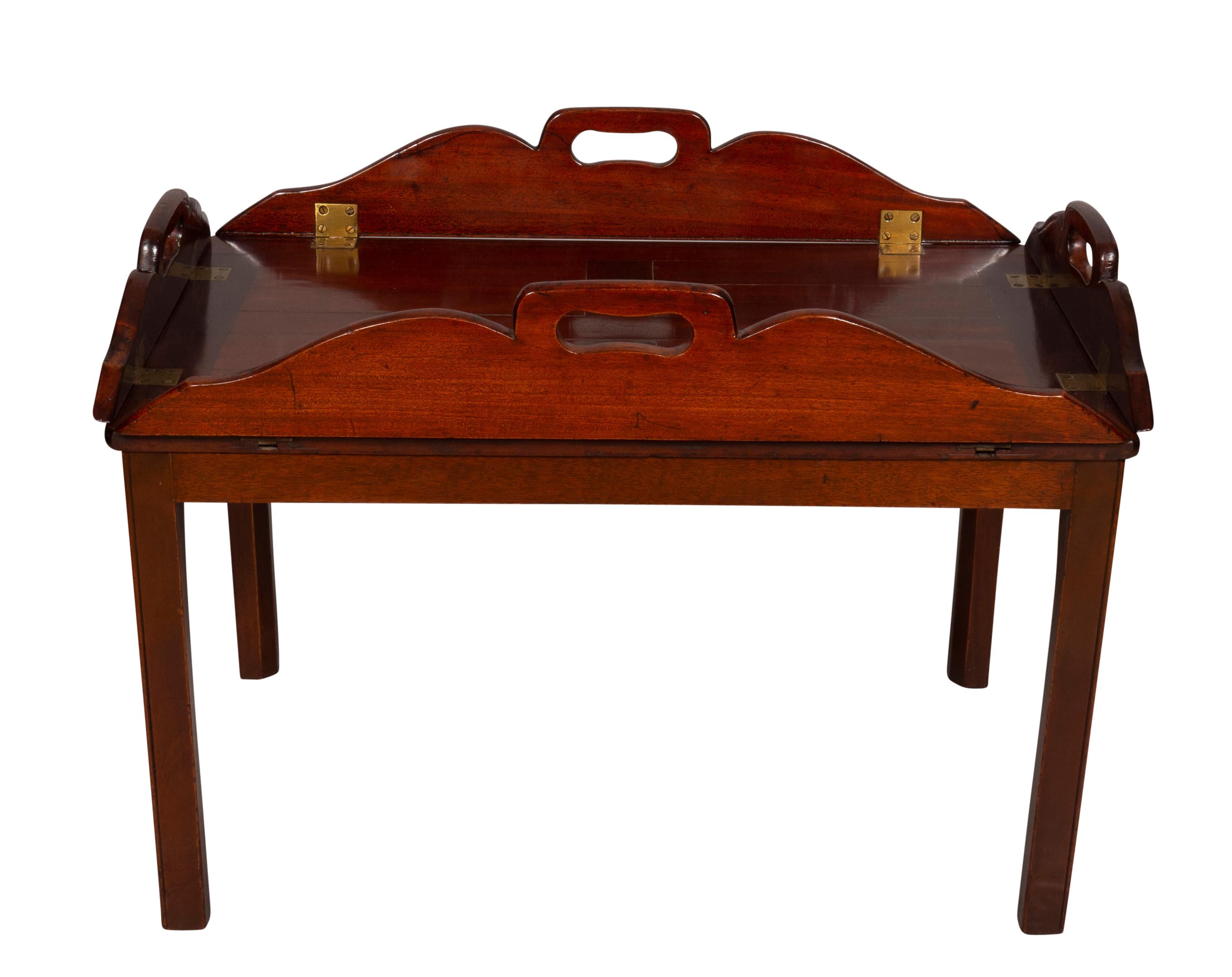 With panelled tray and shaped hinged sides with hand holds on a later base with square section legs. The hinged borders enabled the tray to be stored flat. These were used extensively from Chippendale's Director to the early Victorian era. Later