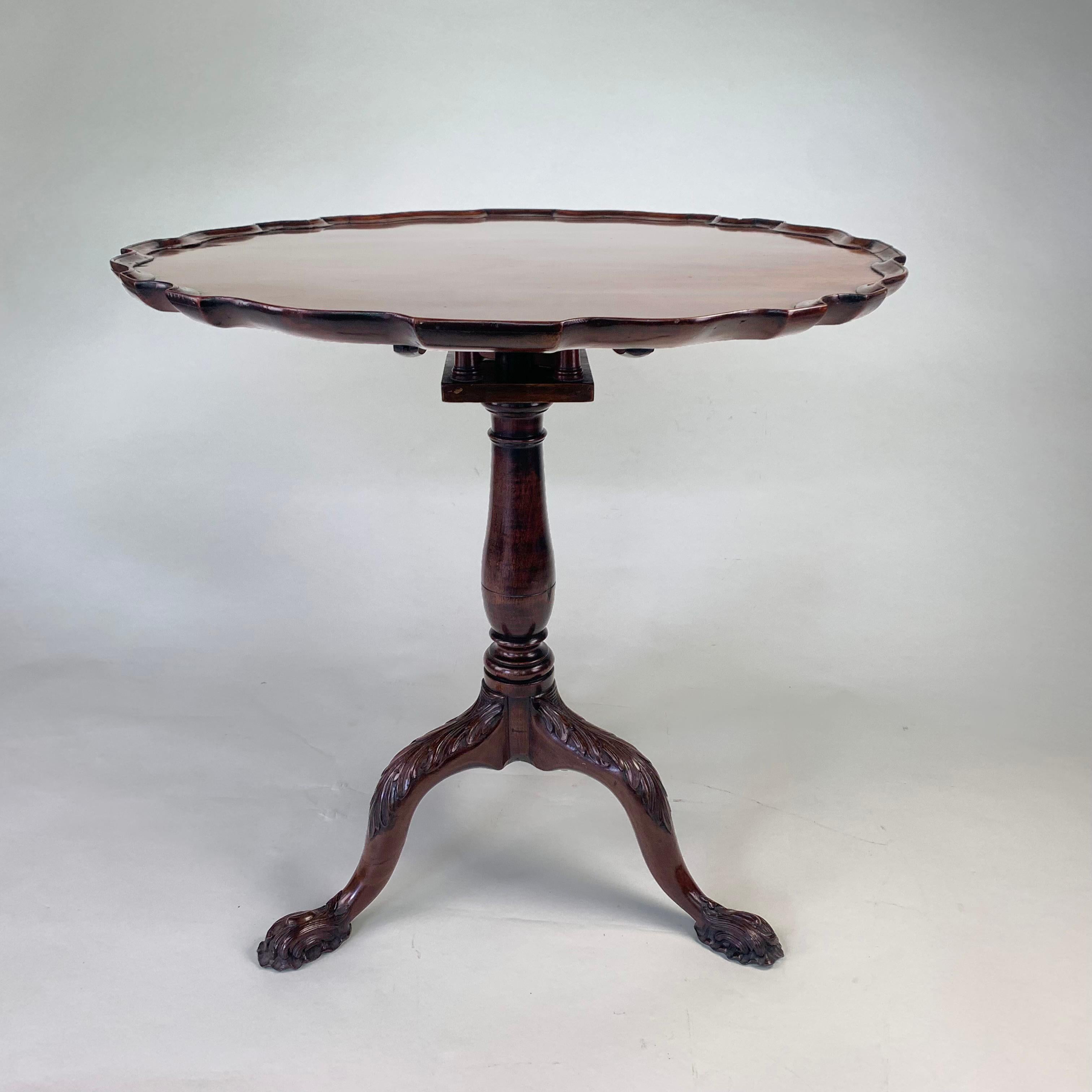 A delightful mid Georgian mahogany tripod table with superb carved decoration throughout. The tilting piecrust top supported on a revolving 'birdcage' stem and profusely carved tripod base with acanthus knees and superb feet.