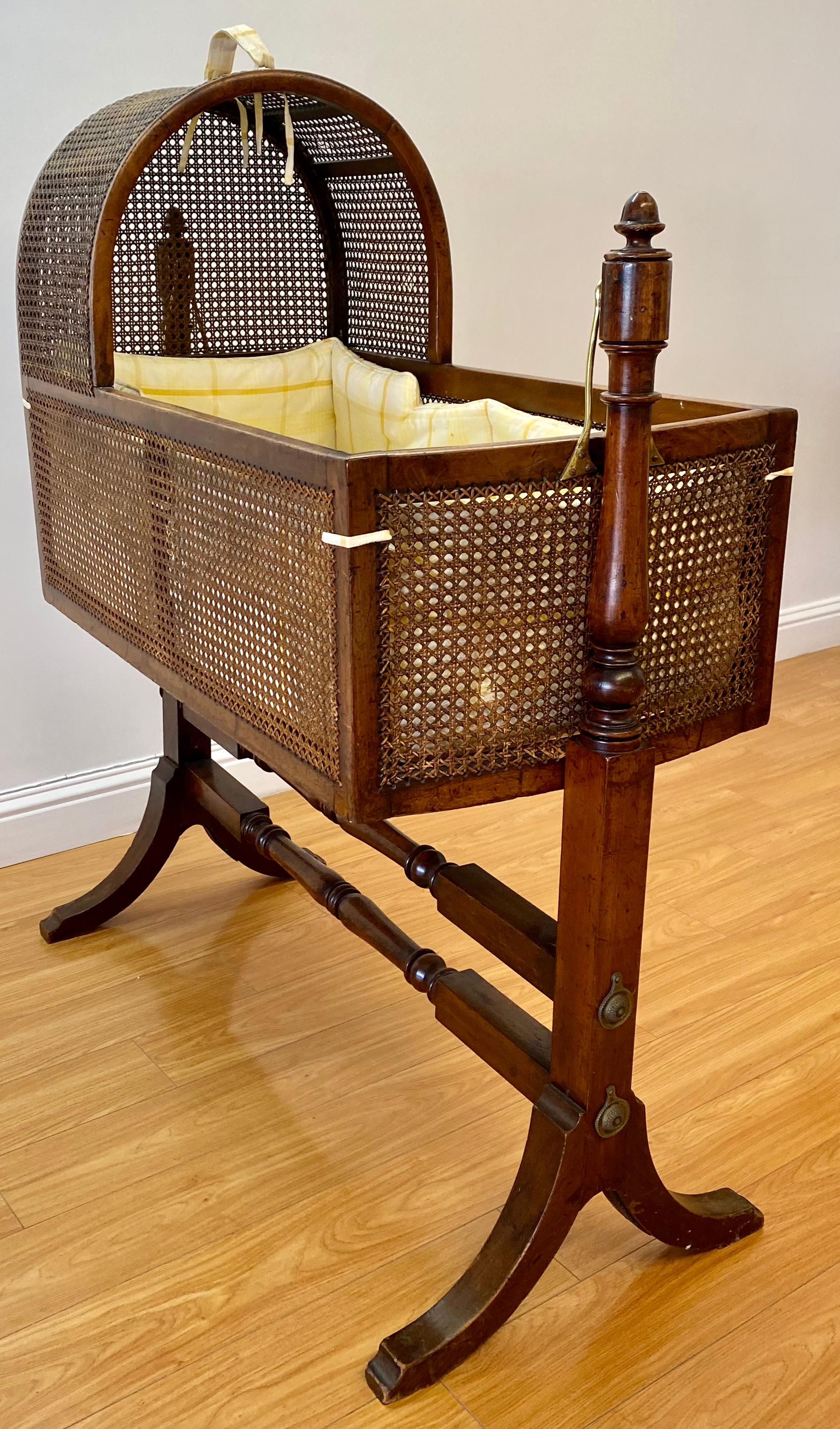 Georgian mahogany child's rocking cradle with caned sides, circa 1820

Handcrafted from solid mahogany with bergere style cane covering the canopy and sides

The slat bottom provides solid support for the cushioned bedding

A label on the