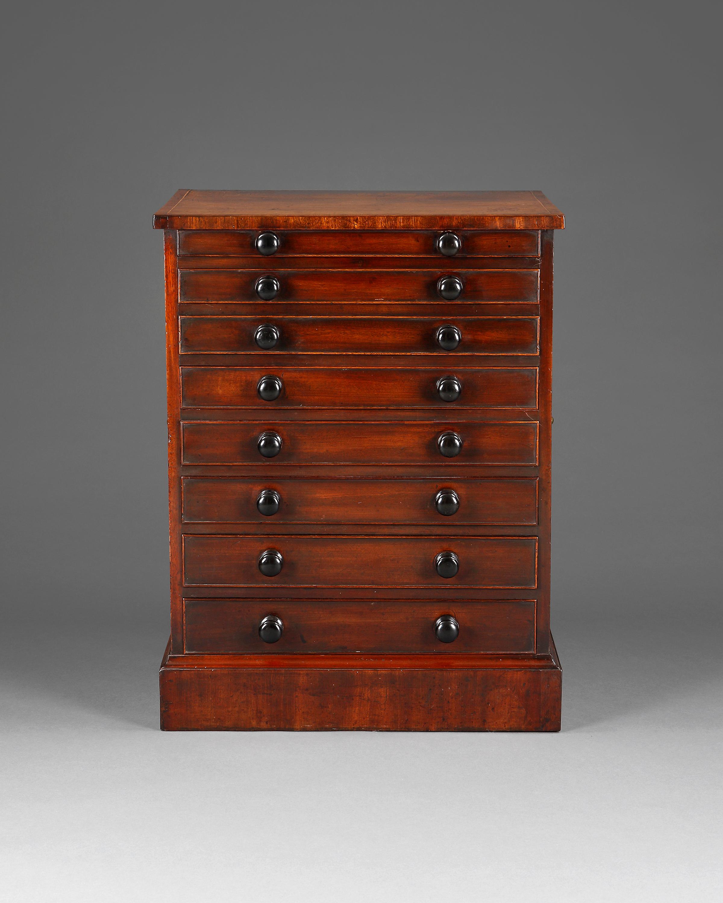 A very fine small George III period mahogany collectors chest with recently lined drawers in velvet. Having eight long graduated cock-beaded drawers and later turned ebony knob handles with original brass carrying handles. 
The whole is raised on a