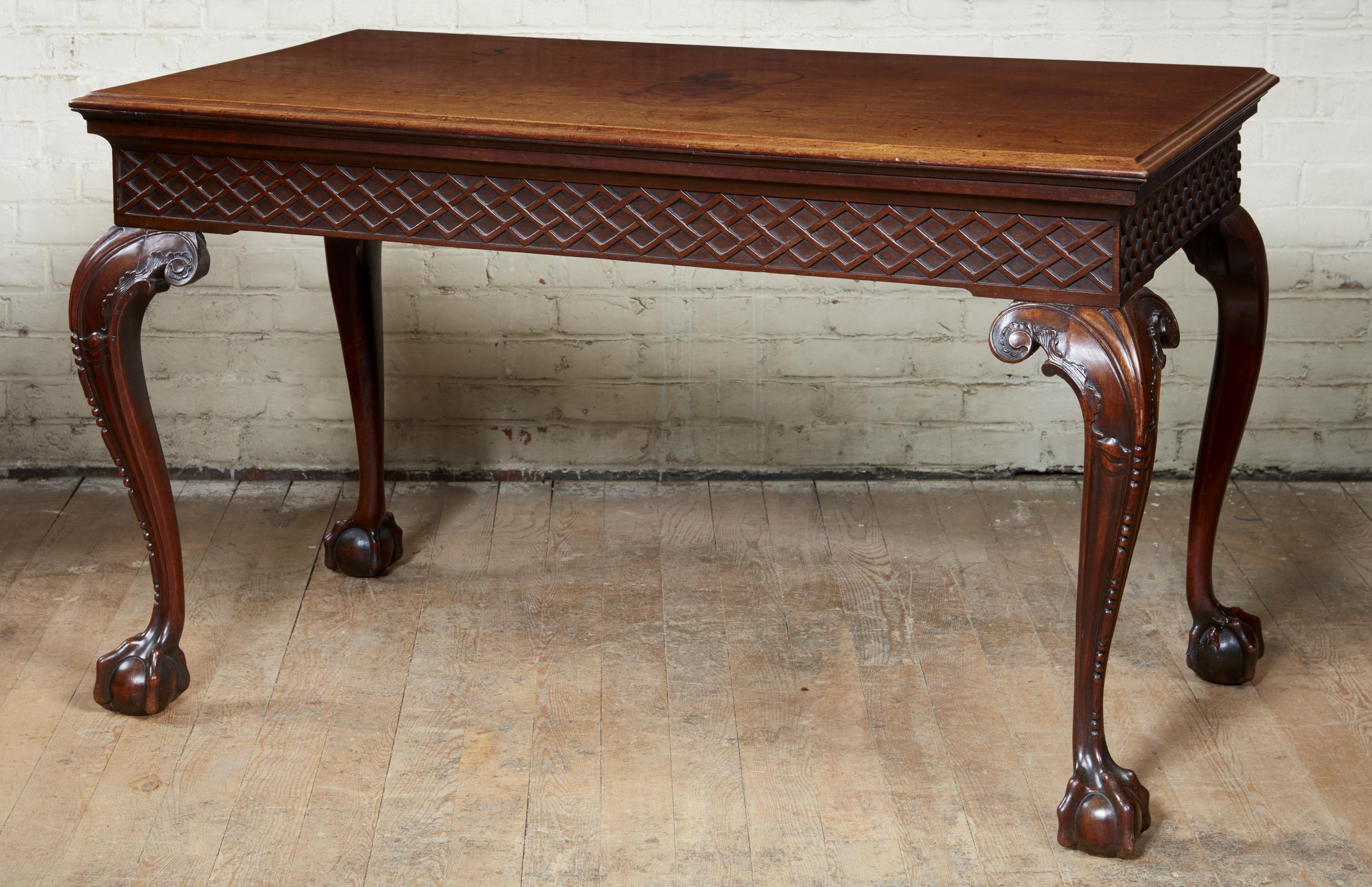 Very fine George II mahogany console table having a single plank top with molded edge over unusually carved blind fretwork apron and standing on boldly carved legs with rocaille carved knees and returns, beaded carved profile and well defined and