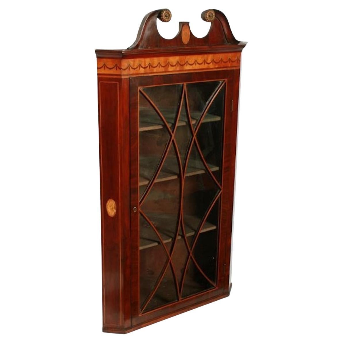 Georgian mahogany corner cabinet

A late 18th to early 19th century Georgian mahogany glazed corner cabinet.

The cabinet has a single door with twelve panes of glass and swept glazing bars or astragals that have box wood line inlay in the