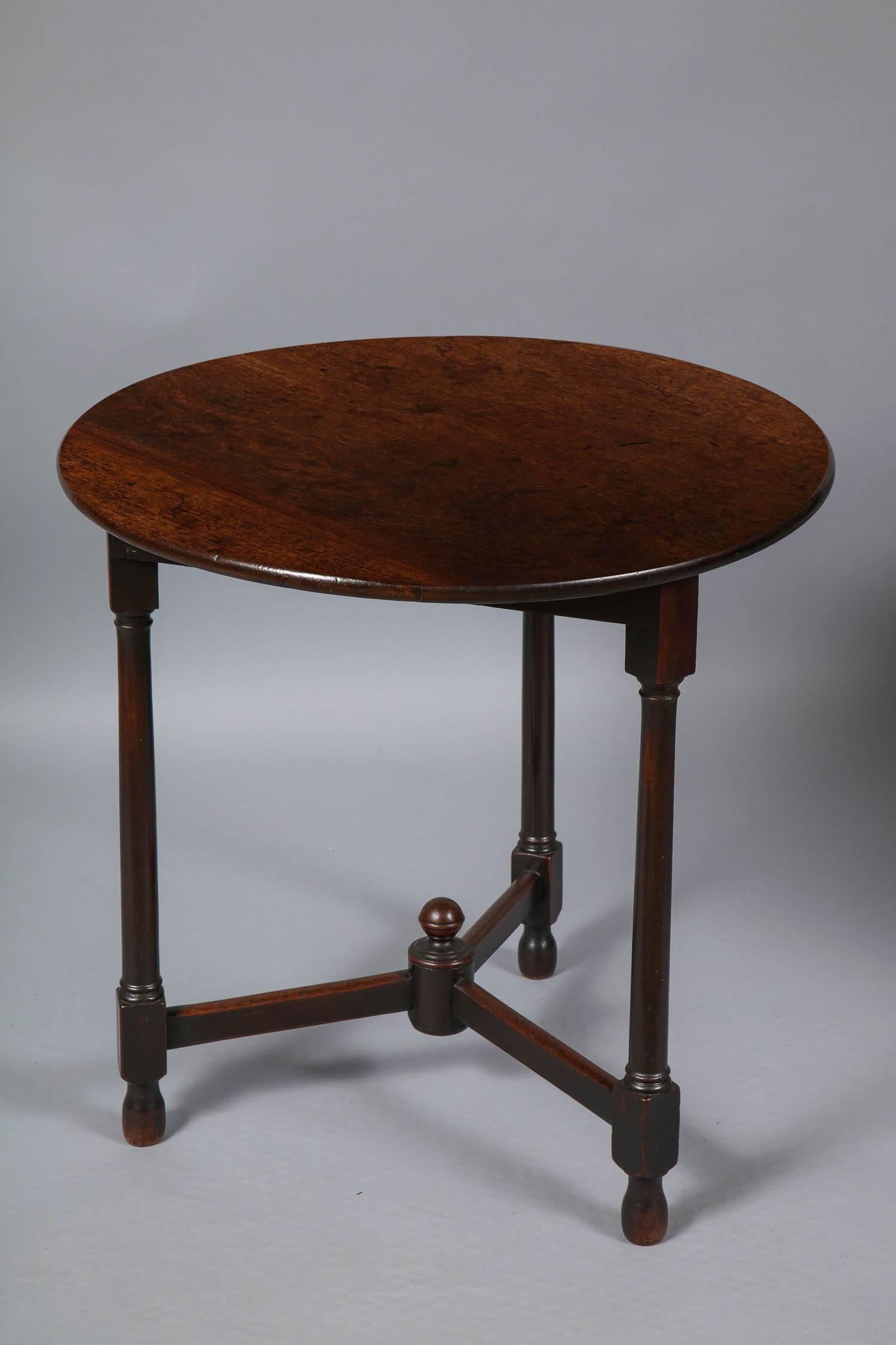 Rare Georgian mahogany cricket table, the top in richly figured plum pudding mahogany having rounded edges, over three cannon-barrel turned legs on blocked feet with original elongated ball feet, joined by three part stretchers joined by central