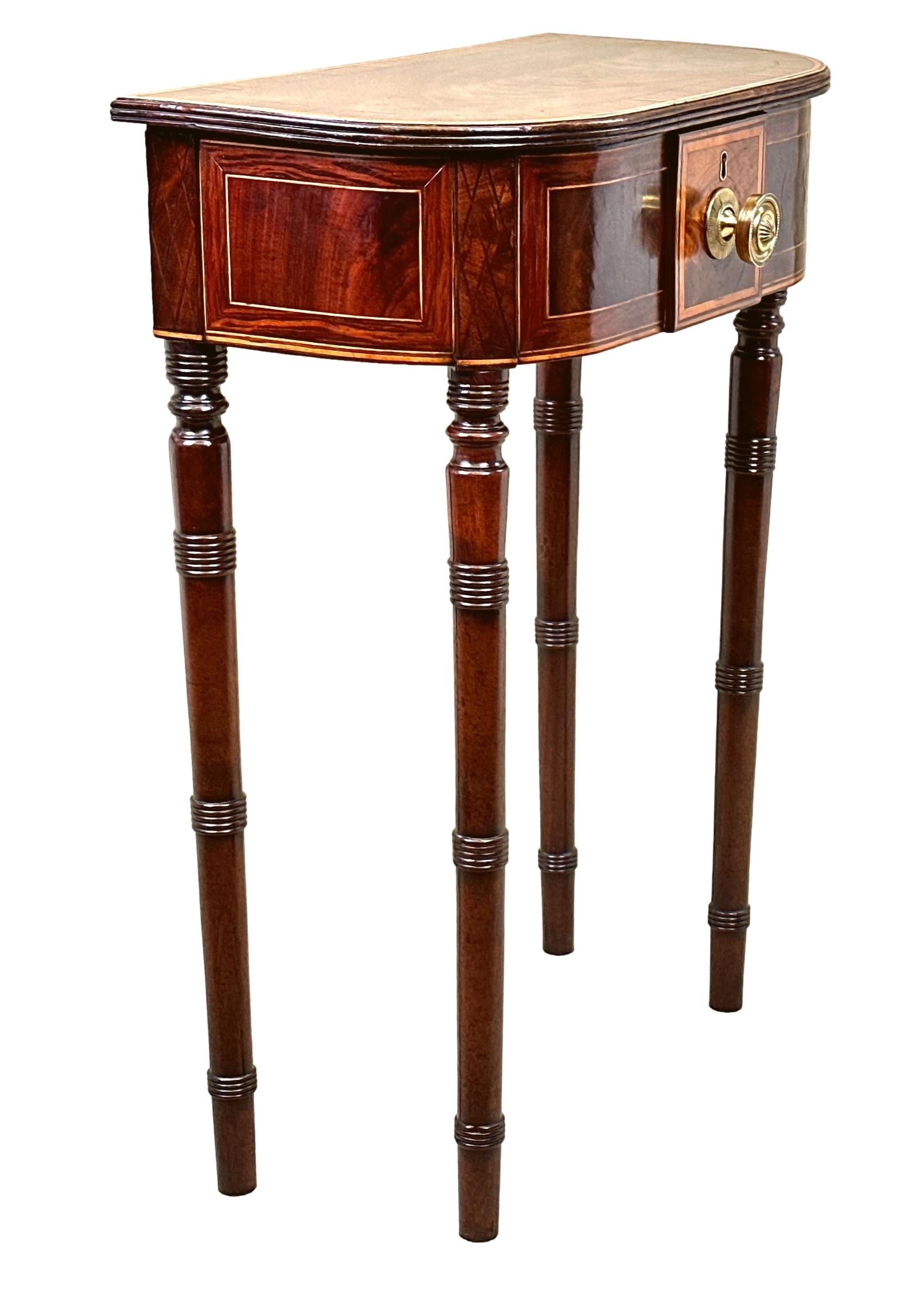 A Very Unusual George III Period Mahogany Occasional Lamp Table, Or Side Table, Of D Shaped Form, Having Well Figured And Crossbanded Hinged Lift Up Top Enclosing Lined Compartment, Over Attractive Deep Frieze With Inlaid Decoration, Raised On