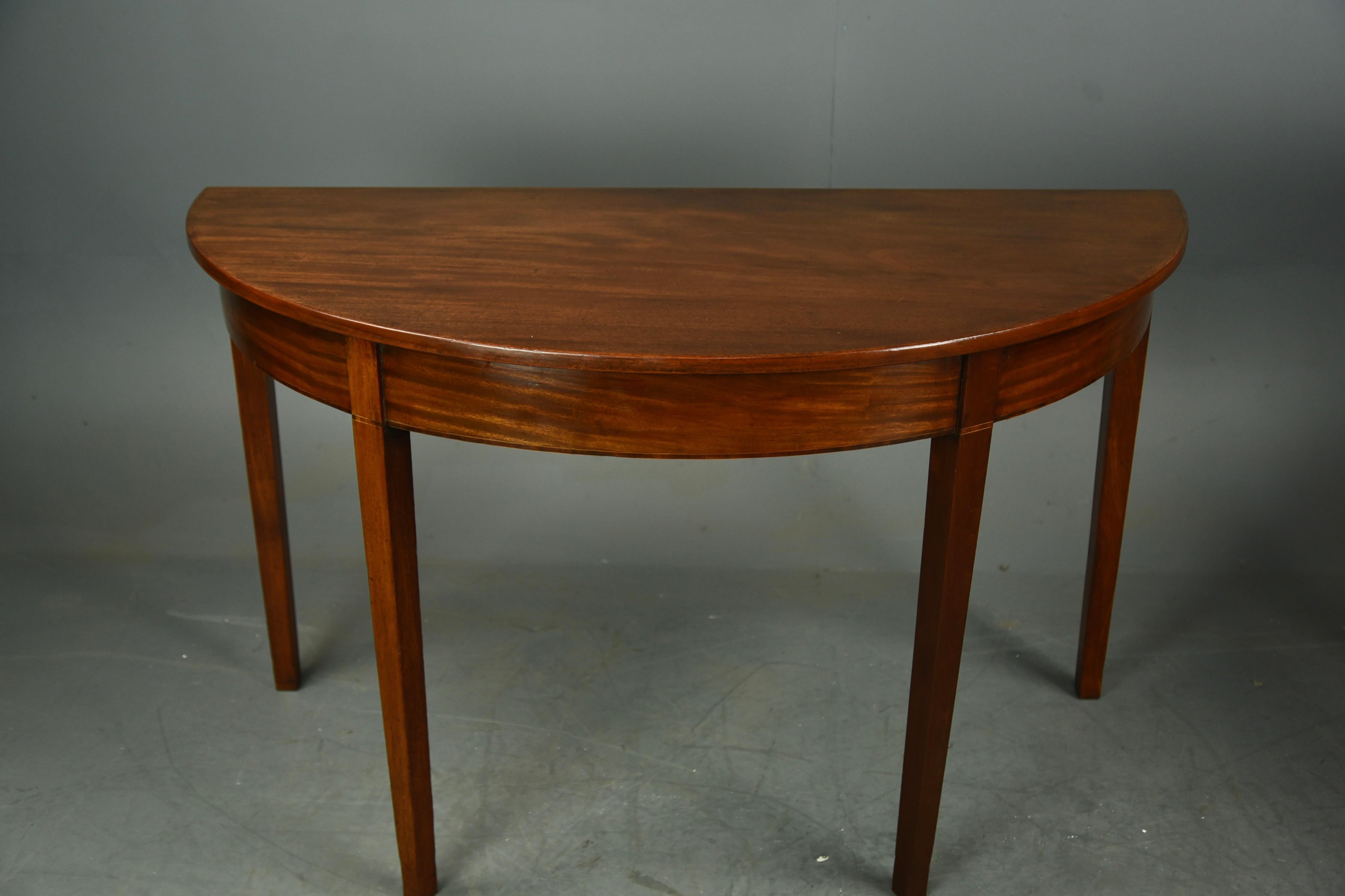 Fine pair of Georgian mahogany Demi lune console tables circa 1800.
The tables are in very good condition with very well grained solid mahogany tops and deep frieze with square tapered legs, they stand very sturdy and are a great size and good