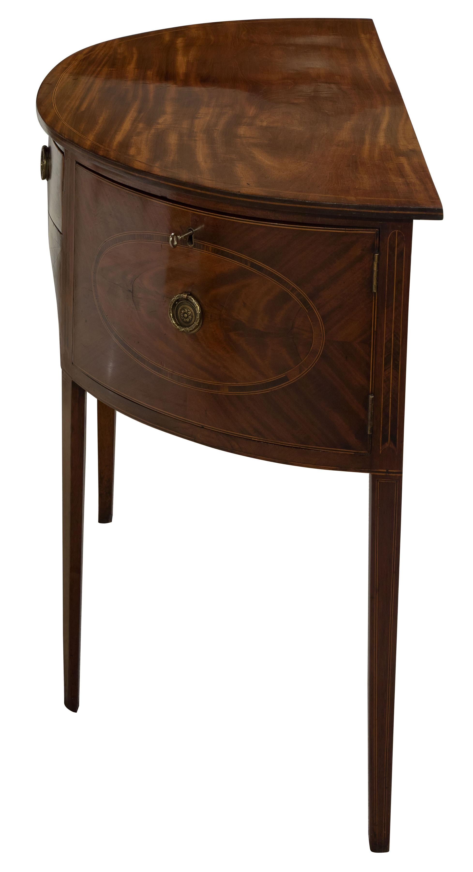 Georgian mahogany demilune sideboard with boxwood and ebony stringing and mahogany crossbanded panels.

circa 1800.