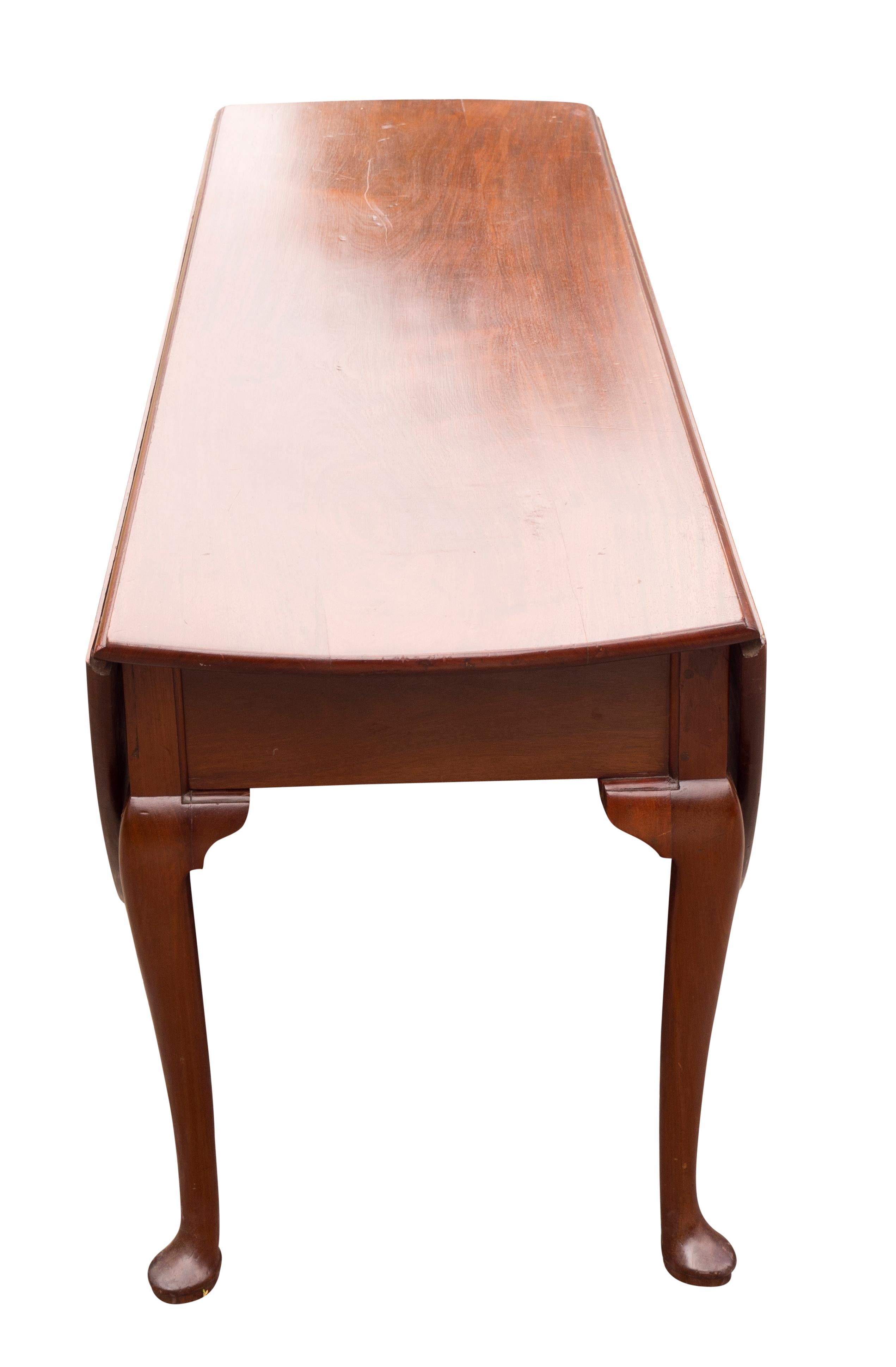 A large table with deep drop leaves opening to almost a circle, with swing out cabriole legs ending on pad feet.