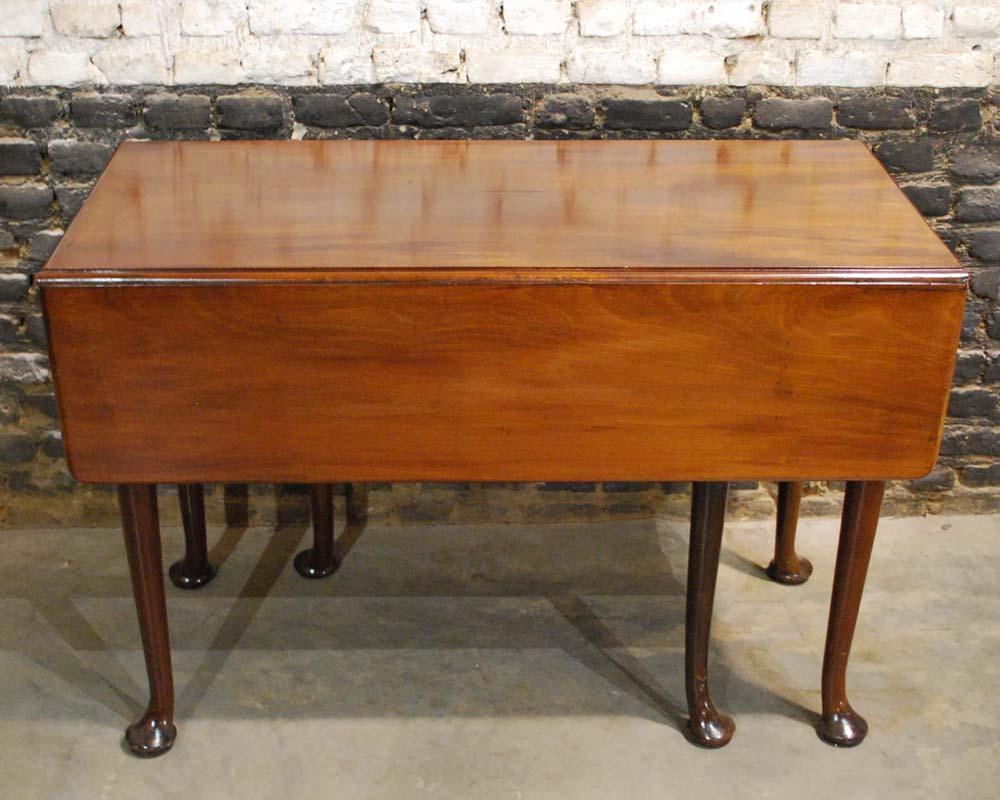 A fantastic early 19th century English George III mahogany drop-leaf gate-leg breakfast table with round straight tapered legs ending in wonderfully large pad feet.
It features a molded rectangular 0.7 inch thick top surmounting a rectangular