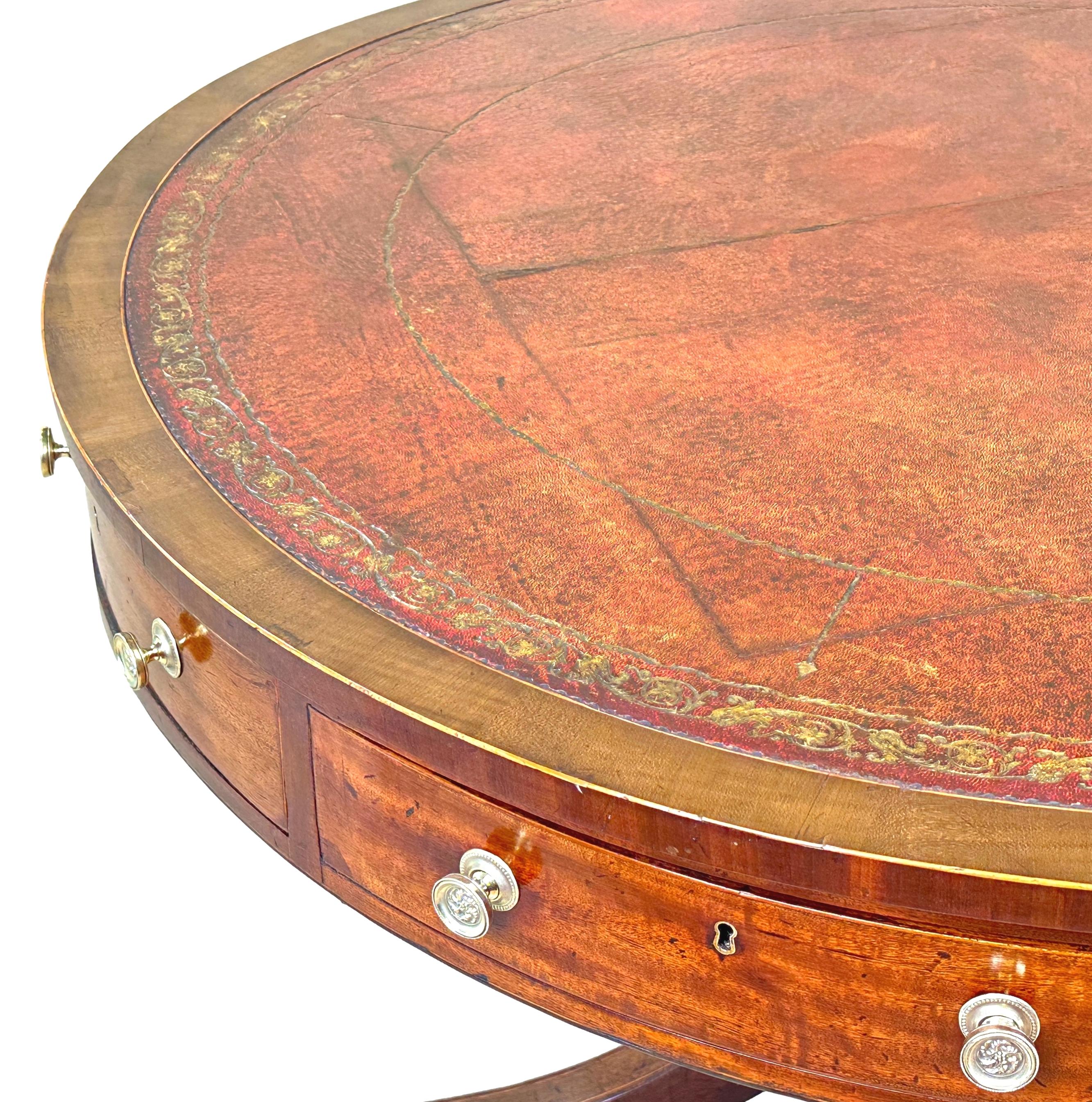 A very fine quality late George III period mahogany central standing drum top library table, having attractive old gilt tooled leather inset to circular rotating top, over frieze with four drawers alternating with four hinged compartments, raised on