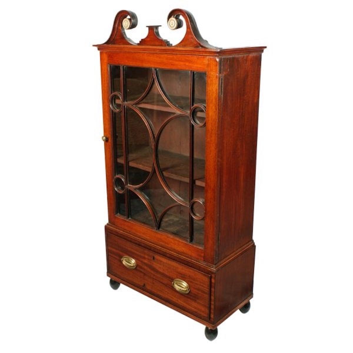 Georgian mahogany dwarf cabinet

An early 19th century Georgian mahogany dwarf cabinet.

The cabinet is of small proportions with a single glazed door, a drawer, a bold swan neck pediment and stands on turned ball feet.

The door has geometric