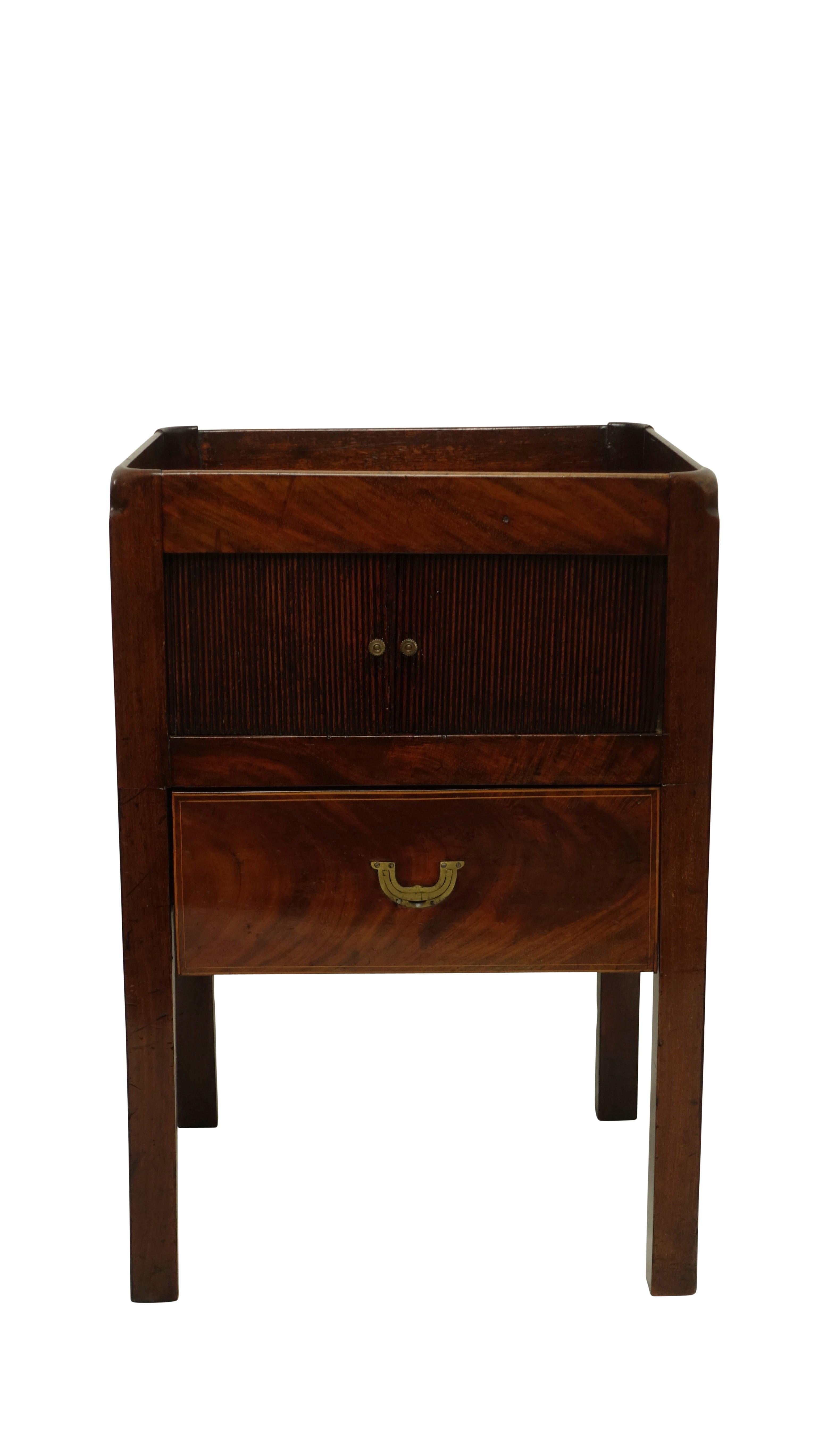 Mahogany wash stand with gallery around the top, above a pair of sliding tambour doors and having a single slide out drawer with campaign style brass pull. England, circa 1800.
 