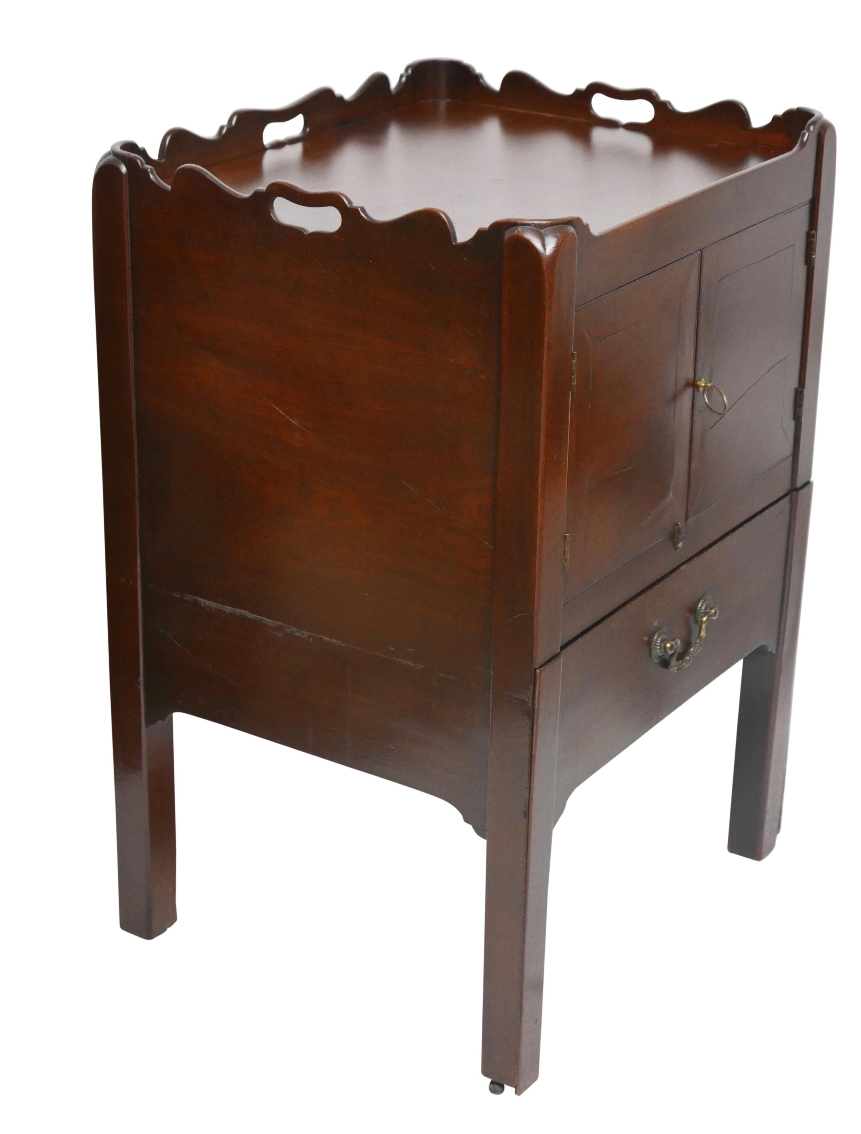 A very nice mahogany wash stand with scallop gallery around the three sides, having a pair of flat paneled doors with a steel and brass pull, above a single shallow drawer, all legs ending with brass castored feet.
England, early 19th