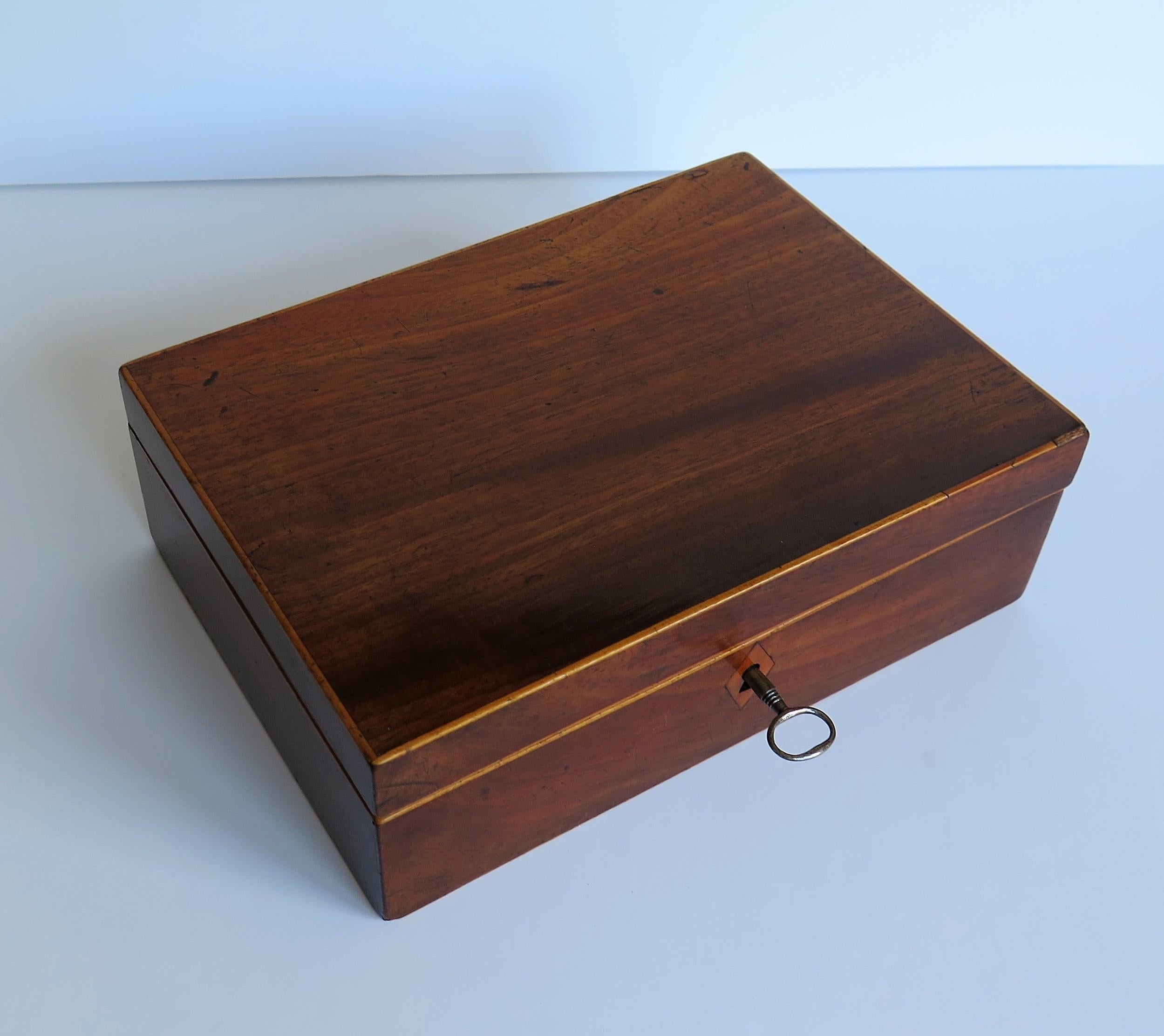 This is a very good quality English Georgian period lidded box, inlaid with boxwood and satinwood with a hinged lid, lock and working key, dating to circa 1800.

The box has a rectangular shape and is handmade of a well figured mahogany, with