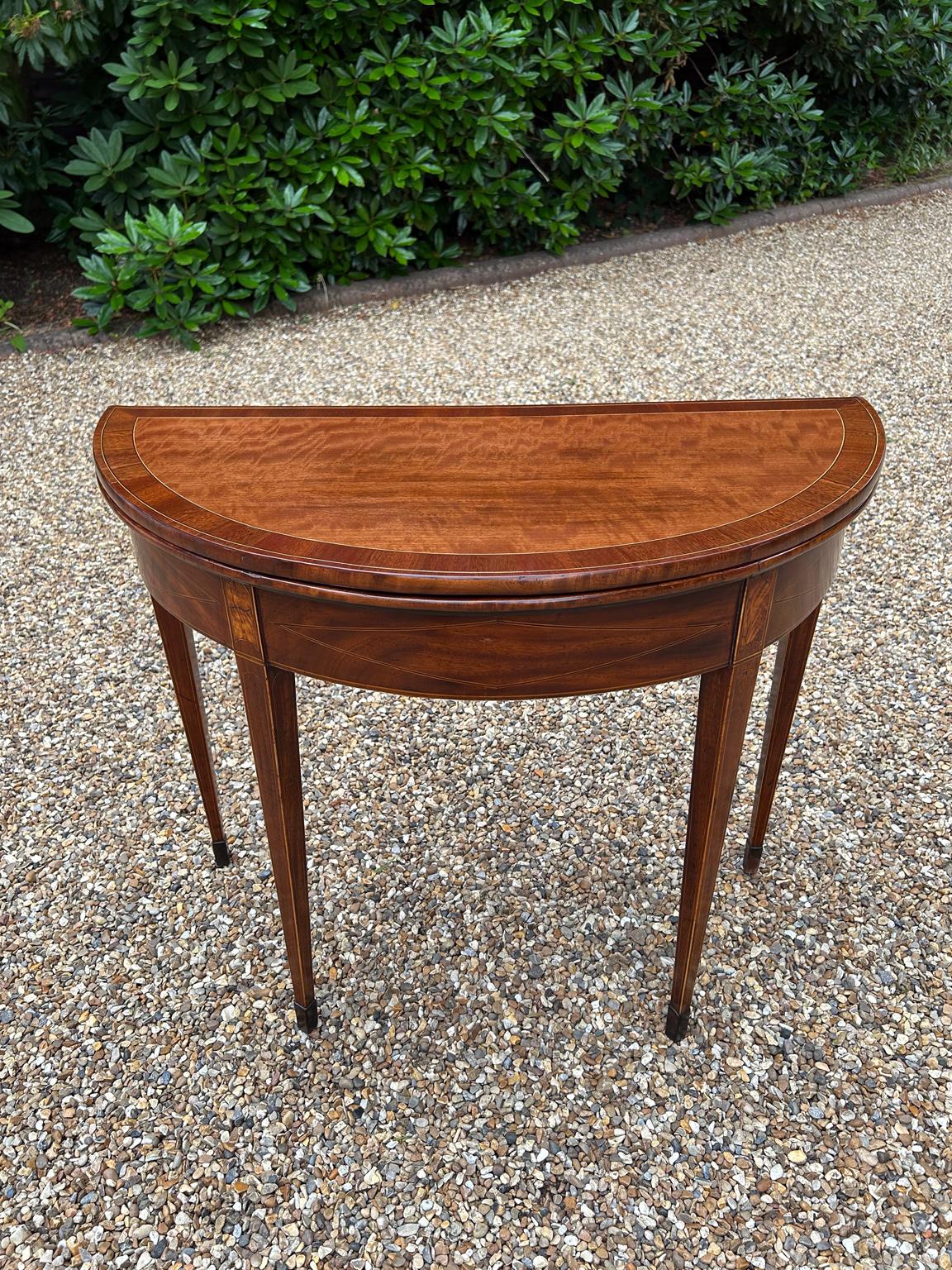 19th Century Georgian Mahogany Inlaid Demi Lune Card Table with a folding top lined with a green baize, crossbanded and line inlaid decoration on square tapering legs with spade feet.

Circa: 1820

Dimensions:
Height:   28.5 inches – 72 cms
Width:  