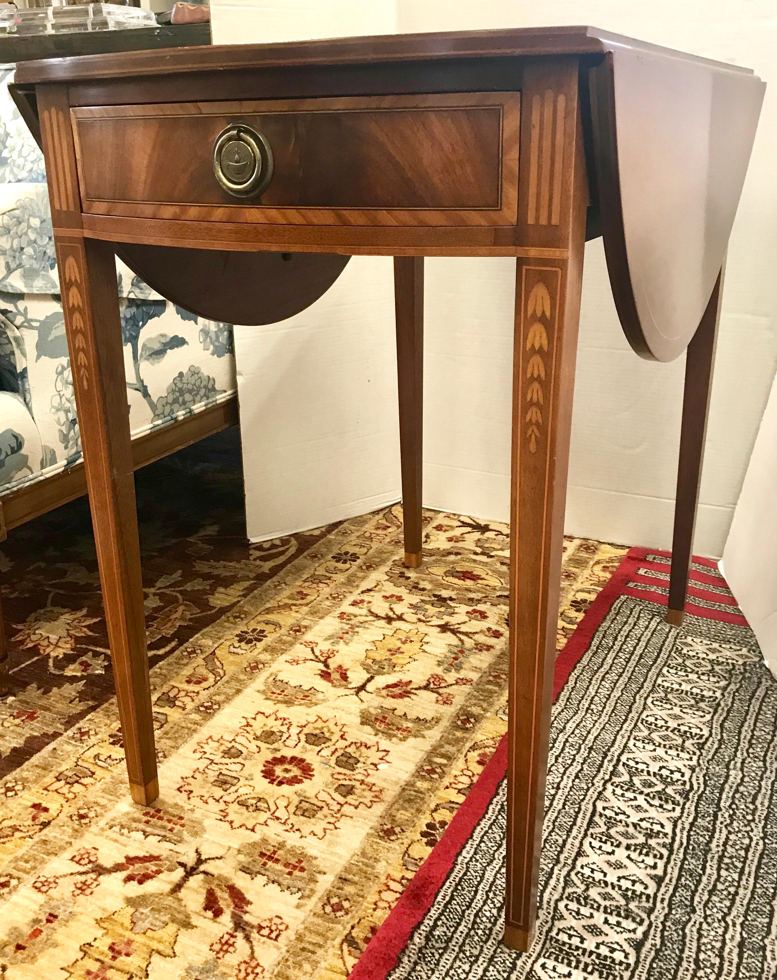 Elegant mahogany occasional table that has fold down leaves and can create game table when leaves are in up position. Inlay runs throughout the piece.