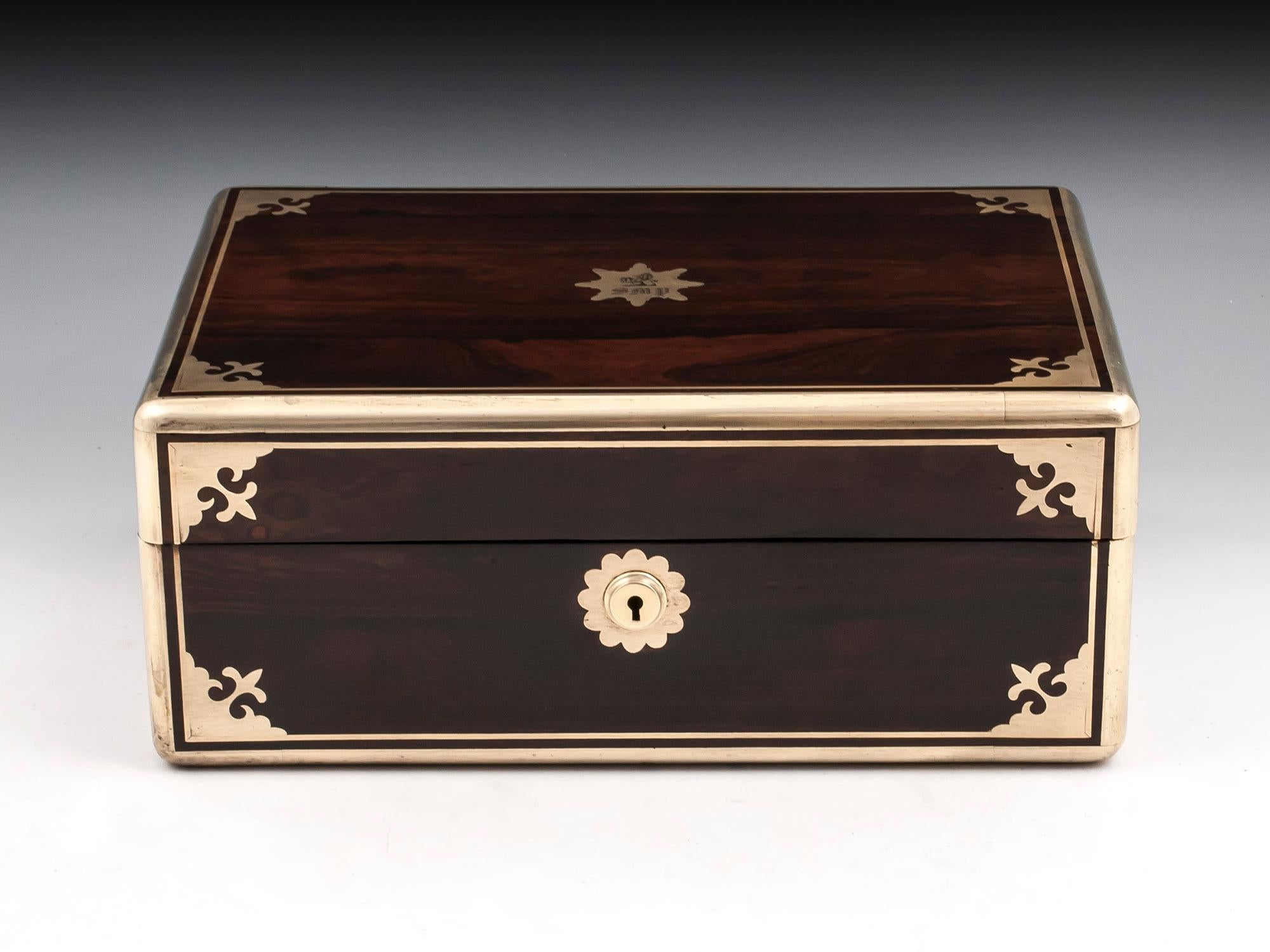 Georgian jewelry box veneered in mahogany bound in thick robust brass with brass stringing and ornate borders. The top is adorned with an engraved star shaped initial plate with a Lion and the letters 