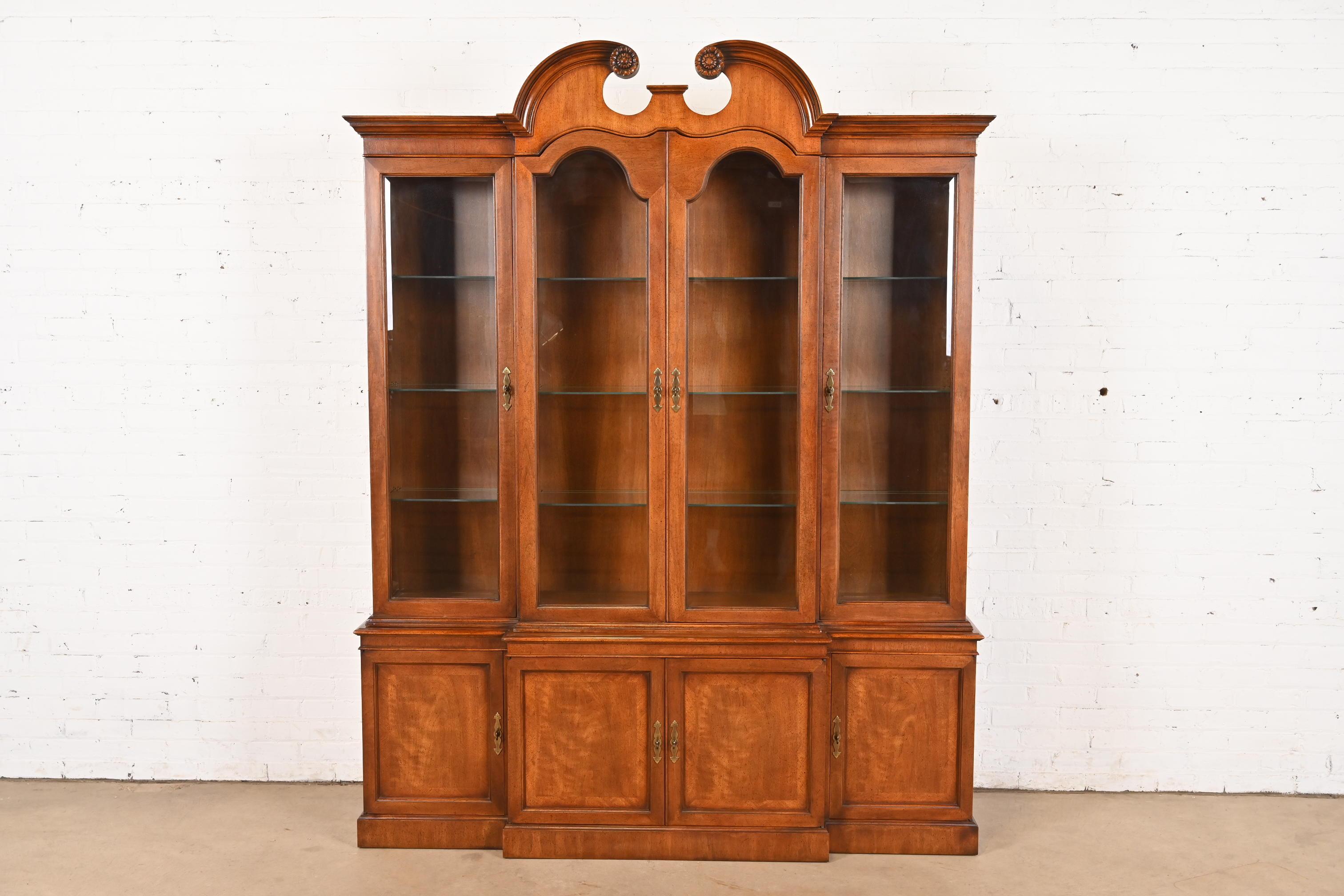 A beautiful Georgian or Chippendale style lighted breakfront bookcase cabinet or dining cabinet

By Mount Airy Furniture Co.

USA, Circa 1980s

Carved mahogany, with glass front doors, and original brass hardware. Interior shelves are
