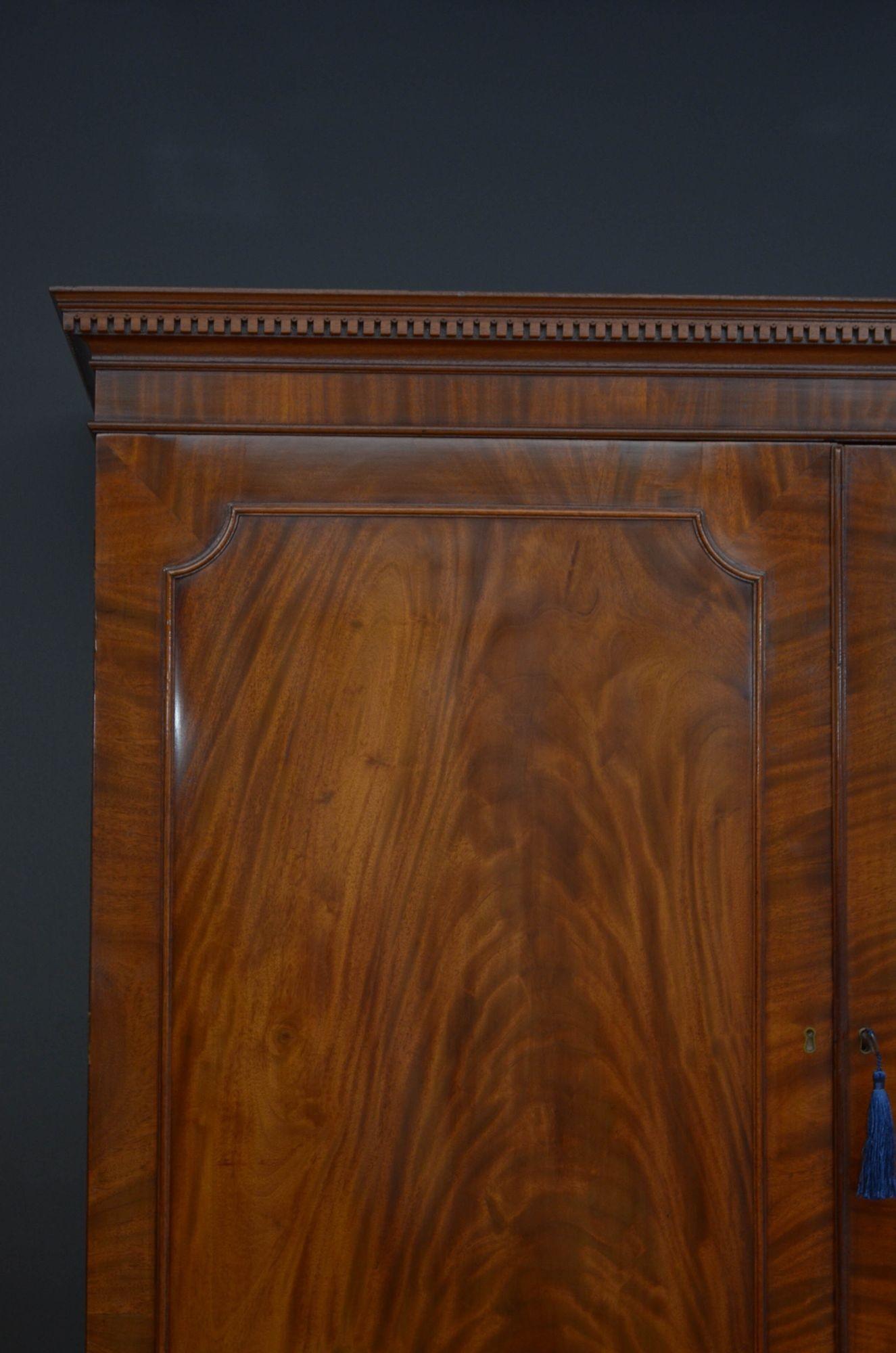 Sn5303 Fine quality George III mahogany linen press, having cavetto cornice with dentil carved frieze above a pair of panelled, flamed mahogany doors fitted with original working lock and a key and enclosing newly lined interior with hanging