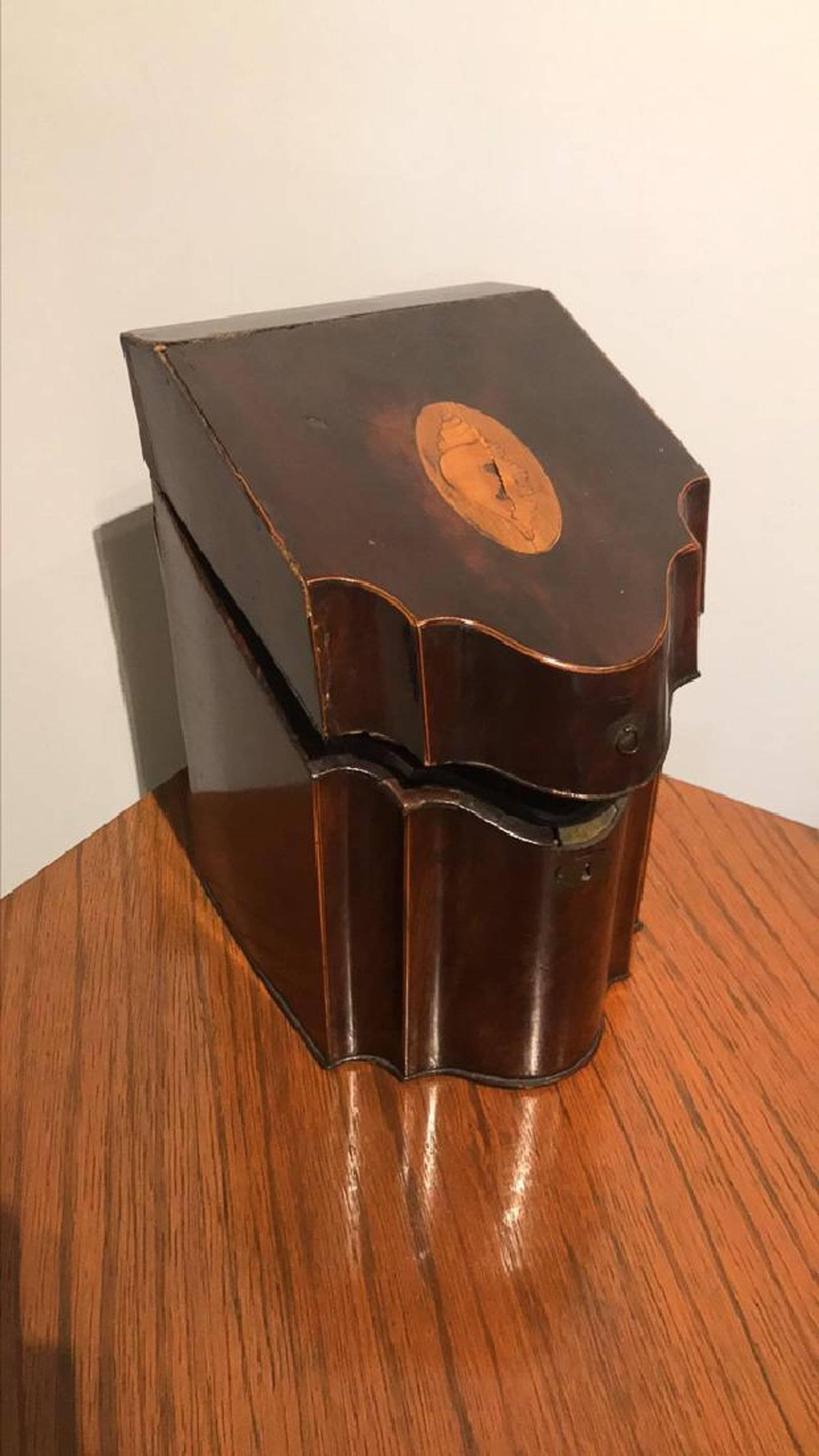 19th century Georgian mahogany slope top and shaped front liqueur box. The satinwood conch shell inlaid top opens to a fitted interior having hand blown gold overlay bottles.

One bottle has chipped lip, box is in old antique condition, good for