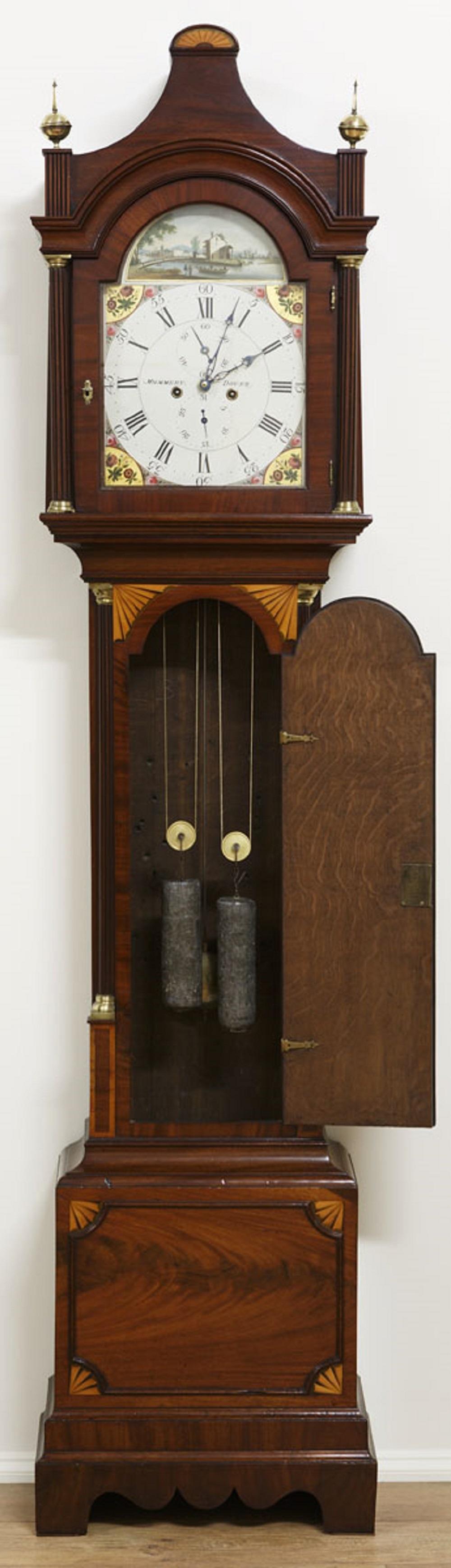 Mahogany Longcase clock by Mummery, Dover.
 
Late Georgian longcase clock in a finely figured mahogany case with satinwood stringing and quadrant shell inlay to the raised, moulded base. Long arched trunk door with reeded canted corners and brass