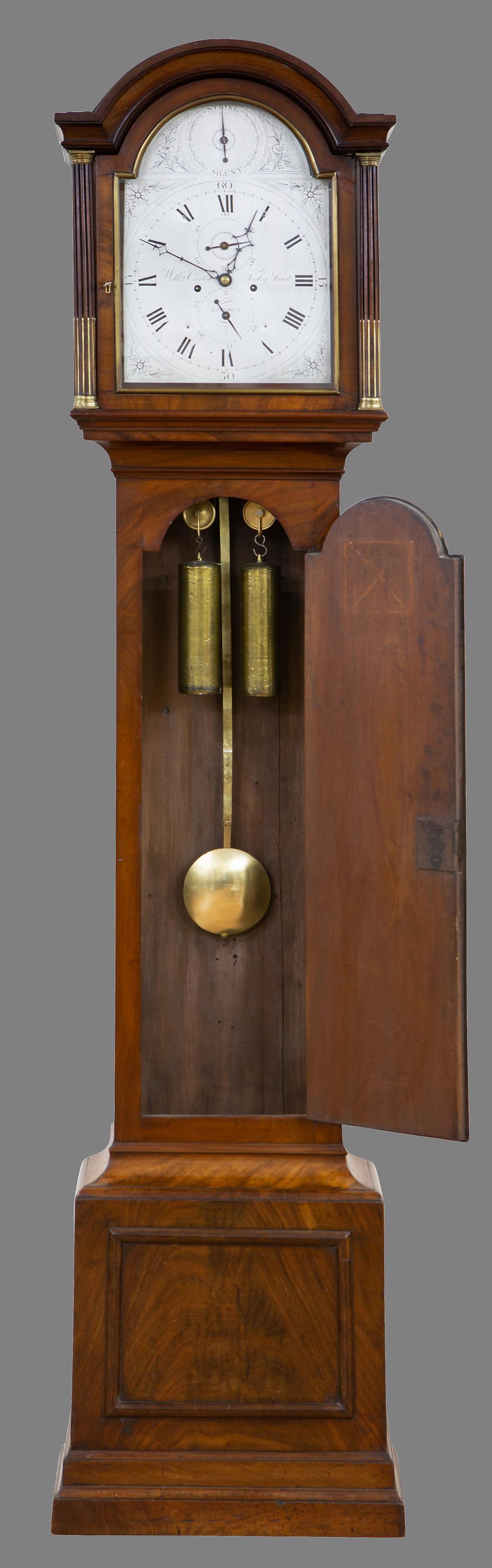 Georgian Longcase Clock

A finely figured flame mahogany case with stepped base, raised moulding to the plinth, long break arch top trunk door with brass escutcheon, reeded canted corners inset with brass corinthian capitals. Break arch hood with